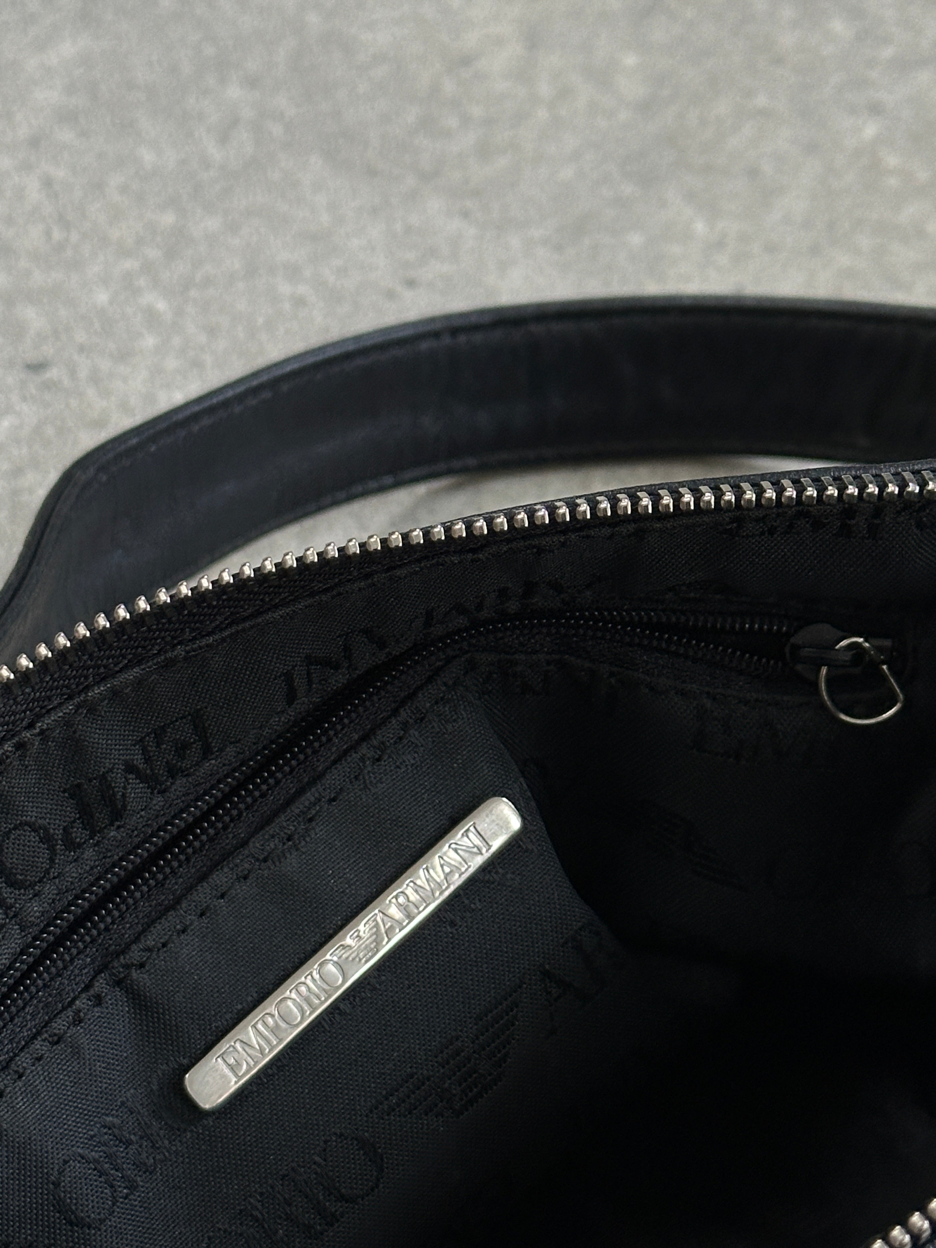 Emporio Armani leather shoulder bag with adjustable strap and sleek design, featuring subtle branding and smooth leather texture.