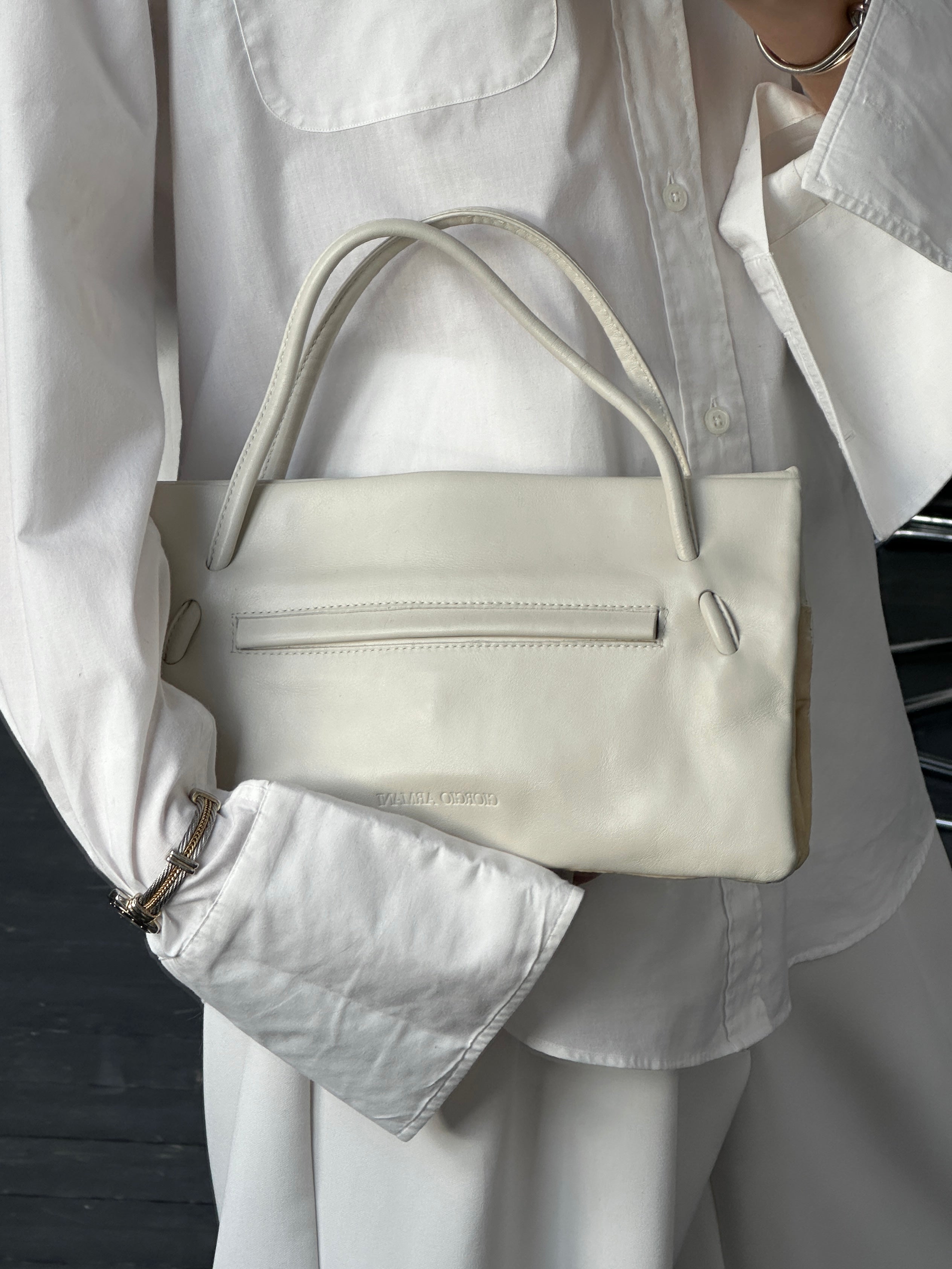 Giorgio Armani Le Collezioni embossed logo handbag with sleek design and textured surface, classic Italian luxury bag.