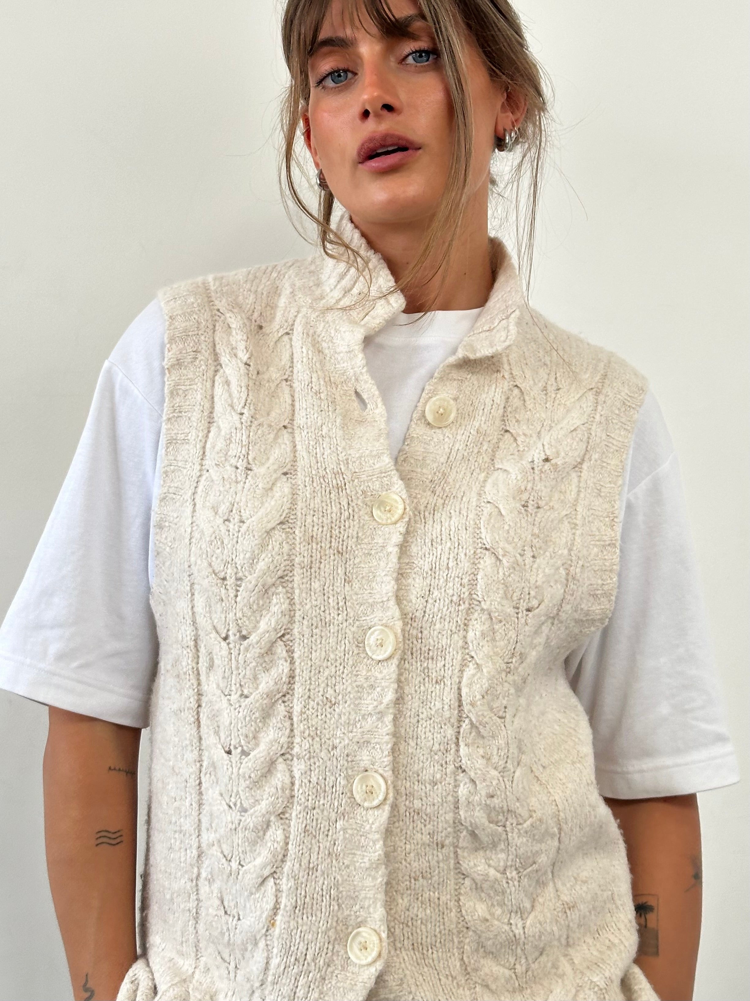 L.L. Bean wool sleeveless knitted cardigan in size L, beige color, with a V-neck and button closure, displayed on a hanger.