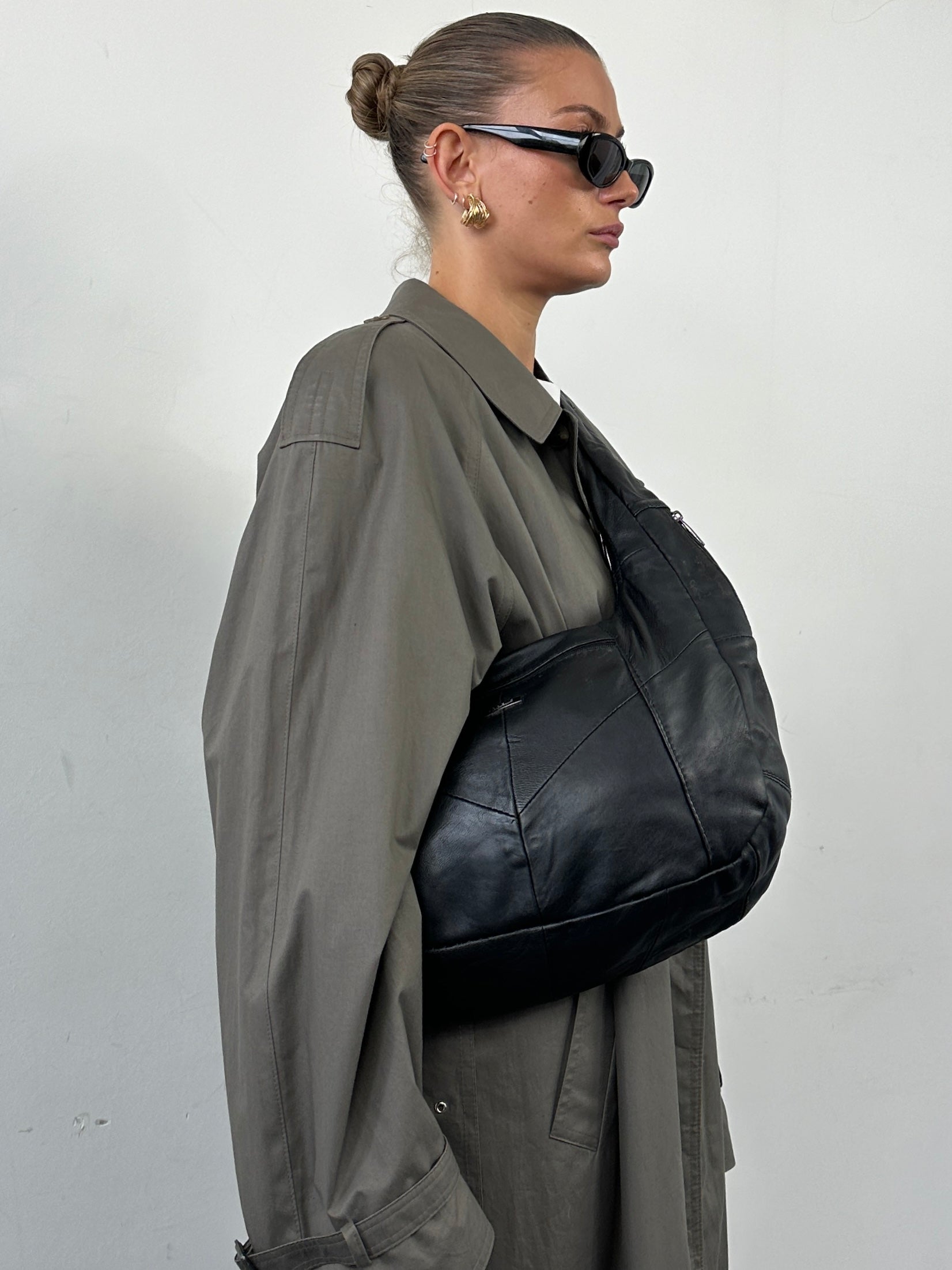 Vintage leather patchwork sling crossbody bag with adjustable strap and multiple compartments, featuring a stylish vintage design.