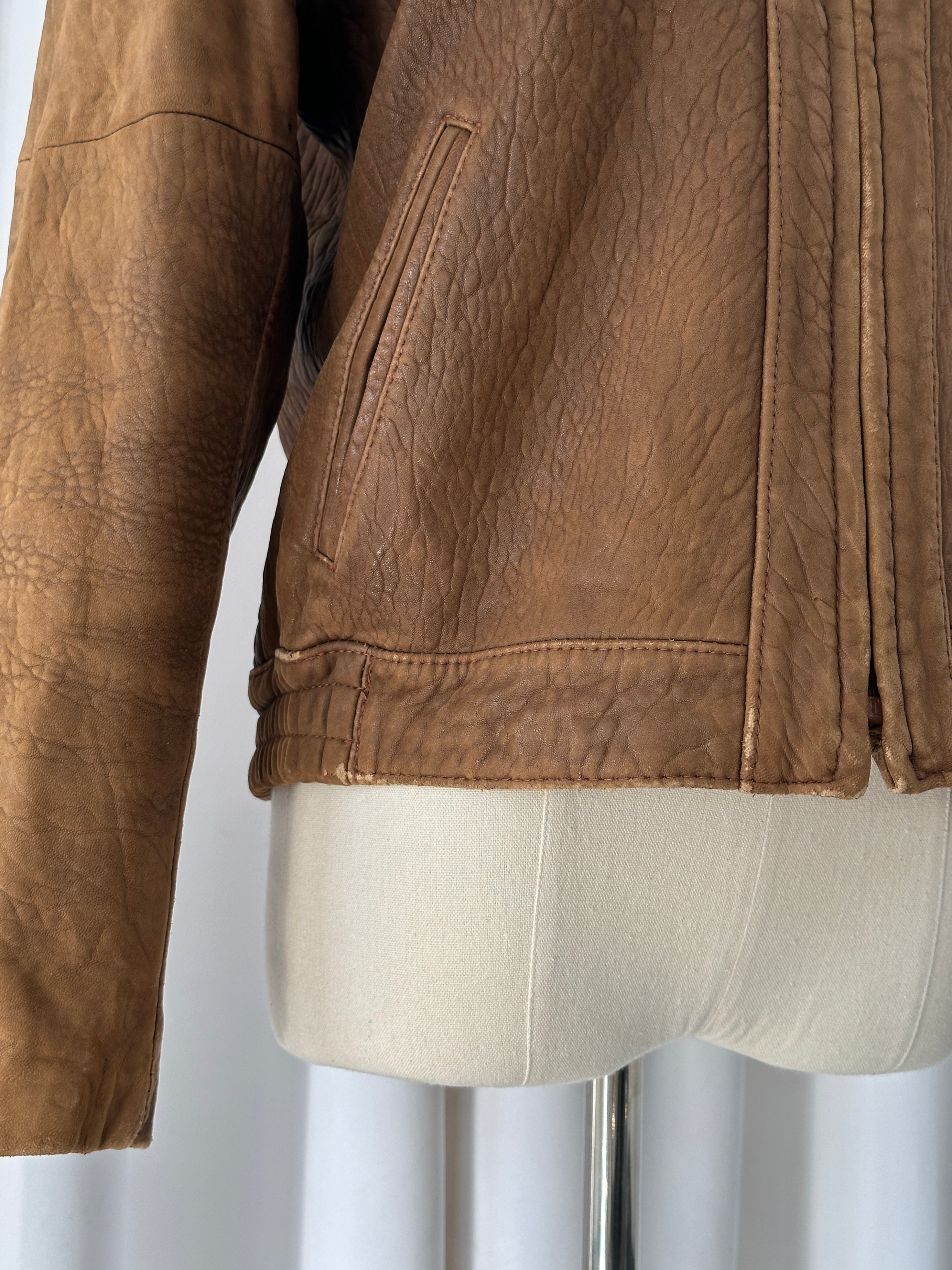 Vintage USA 1980s leather bomber jacket in XS/S, featuring classic design and distressed leather, displayed on a hanger.