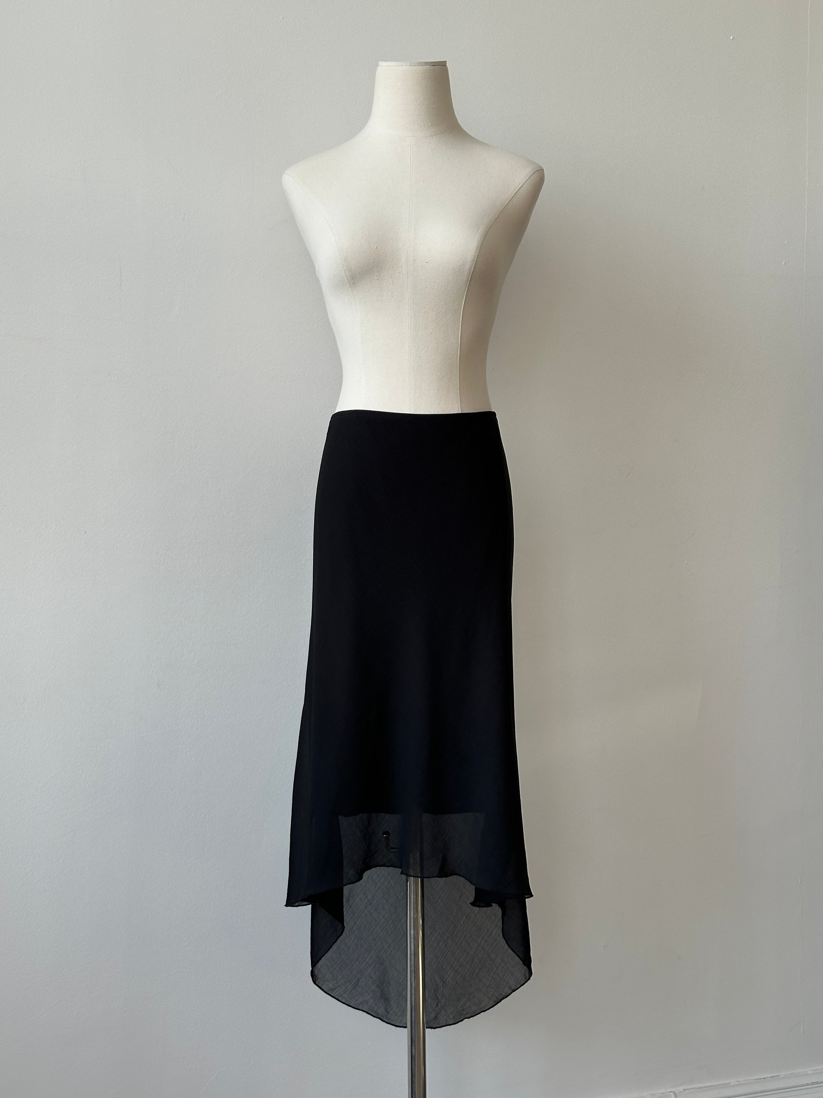 Vintage 1990s USA asymmetric midi skirt in denim with a high waist and uneven hem, displayed on a hanger.