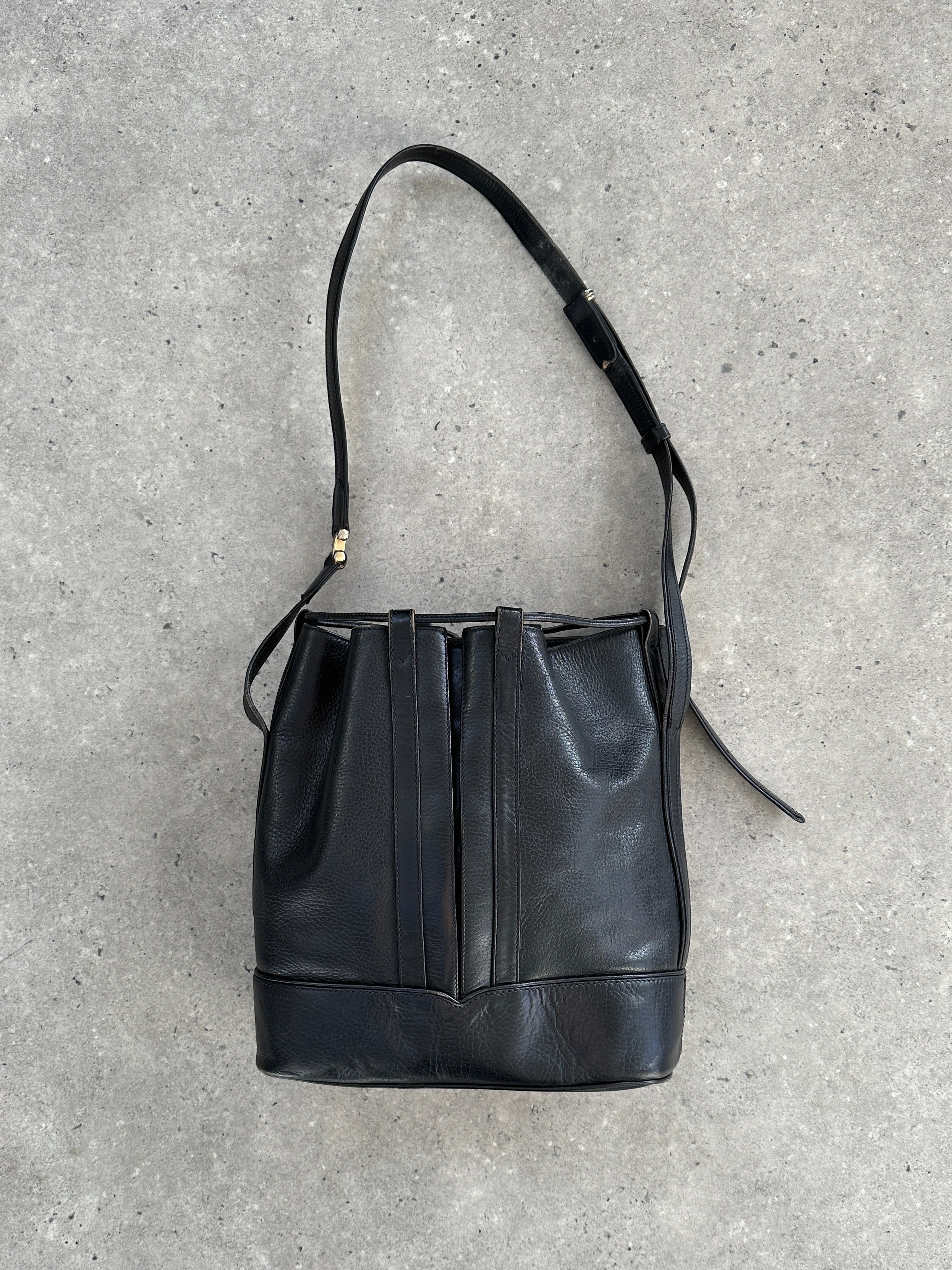 Cartier 1980s leather bucket bag with adjustable strap and classic design, showcasing elegant craftsmanship and timeless style.