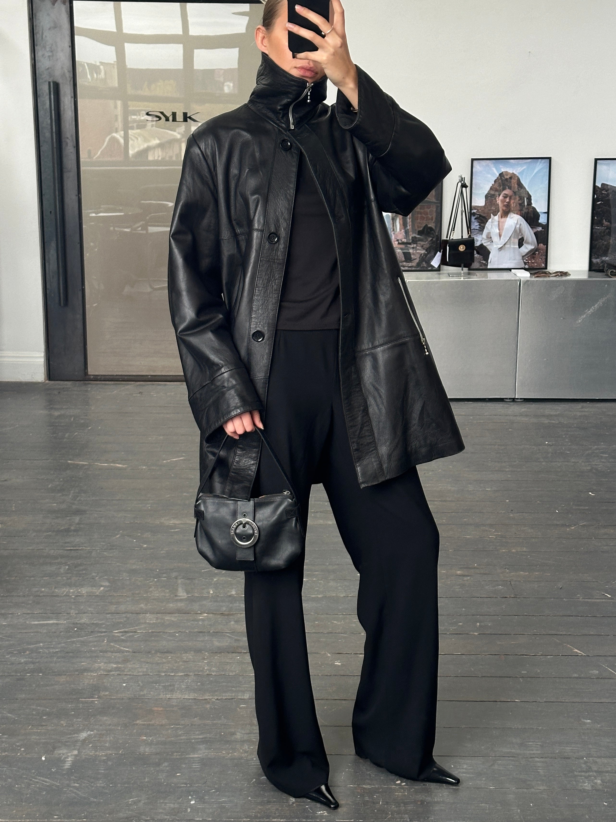 Conbipel 1990s smooth leather high neck coat in size L/XL, featuring a sleek design and high collar, displayed on a hanger.