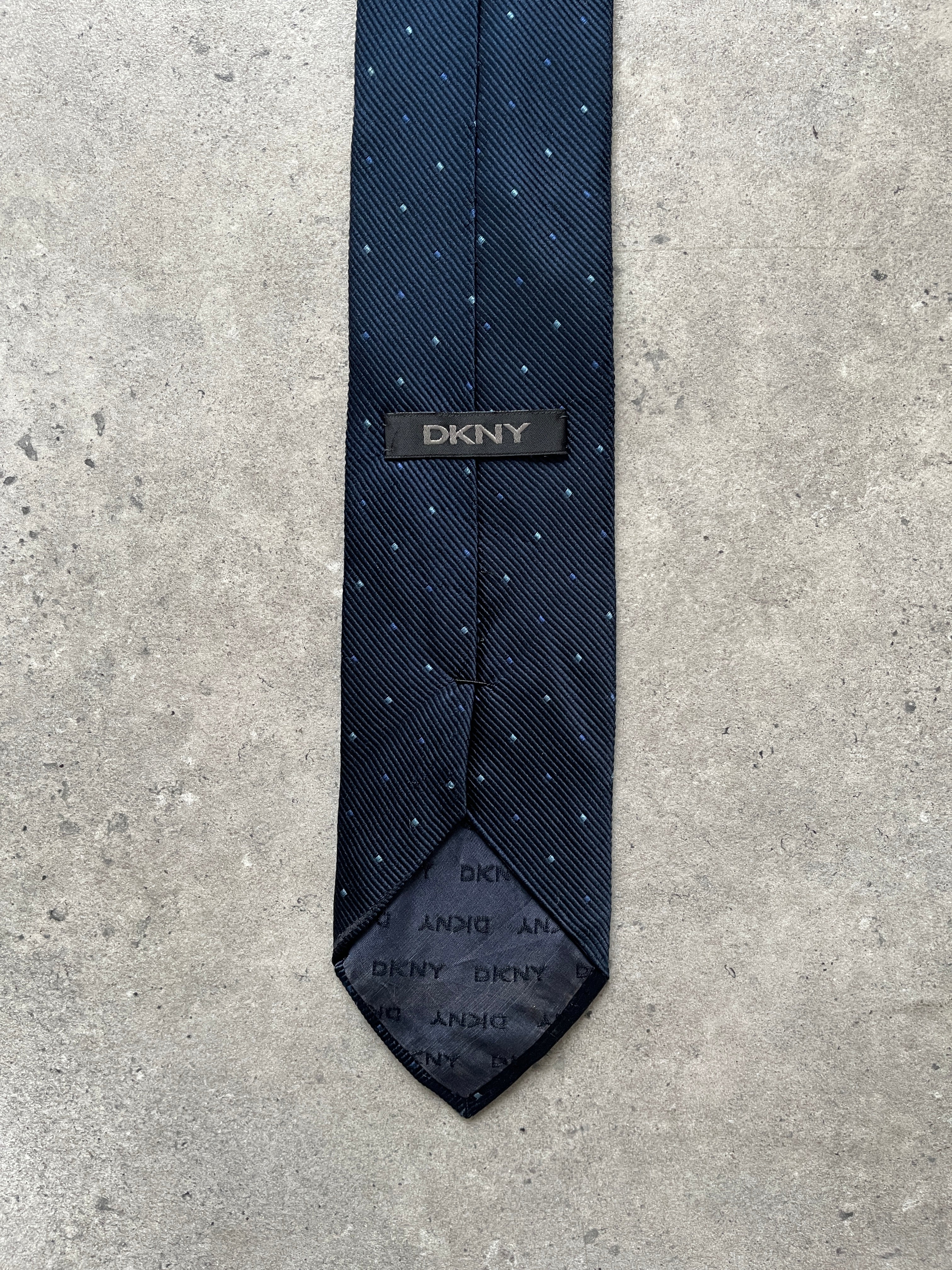 DKNY 2000s pure silk woven print tie displayed flat, showcasing intricate pattern and luxurious silk fabric.