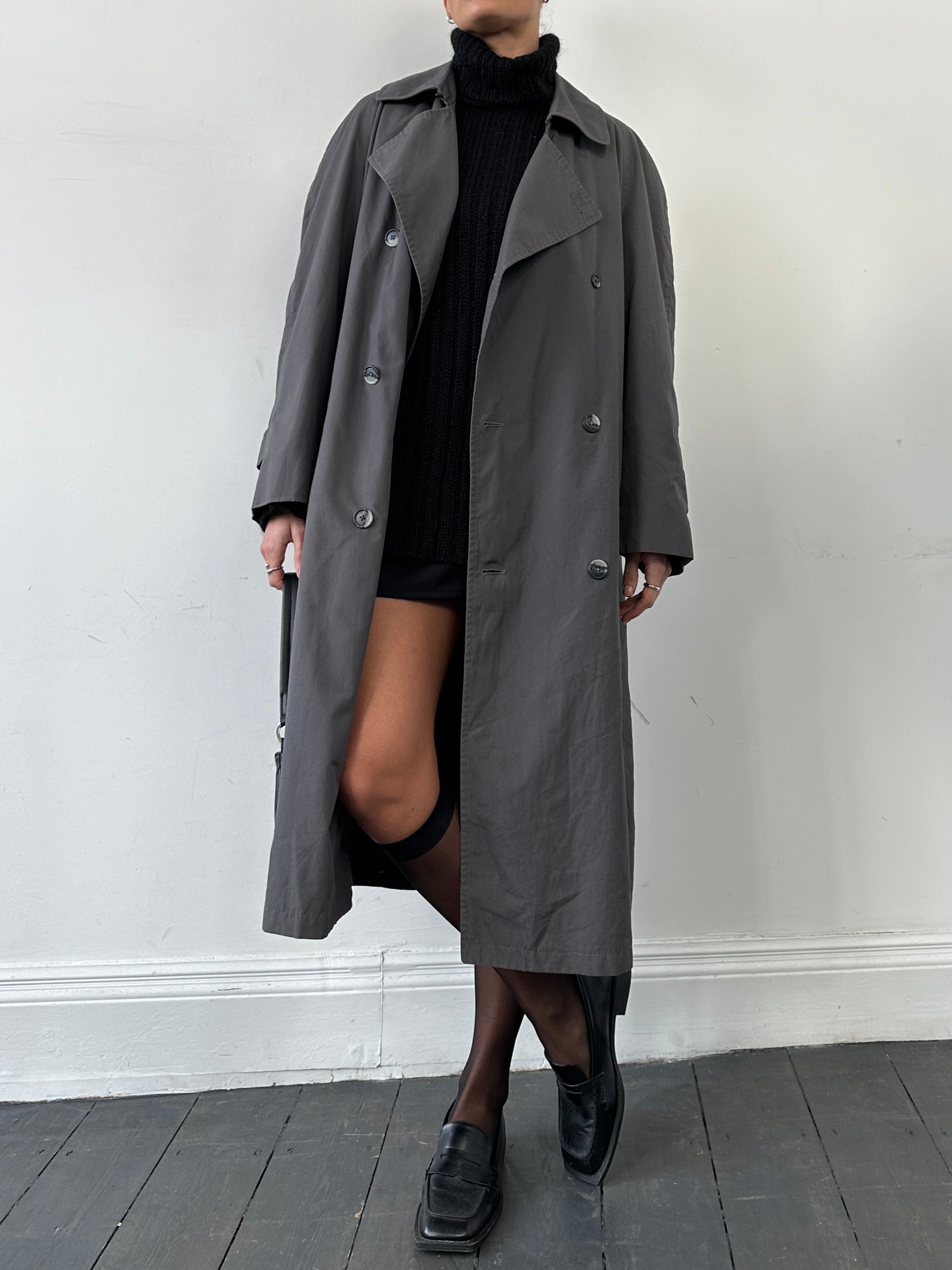 Christian Dior double-breasted trench coat in size L, featuring classic design with belt and button details, displayed on a hanger.