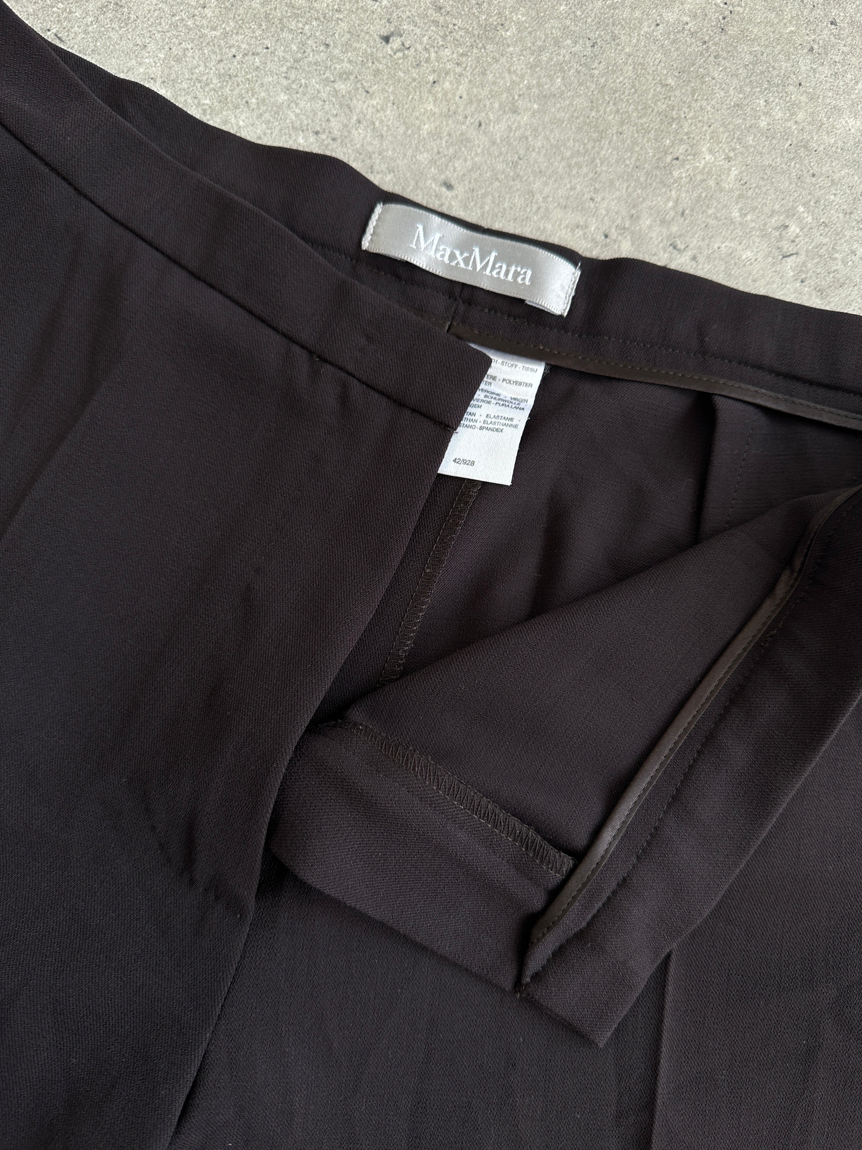 Max Mara minimal wool tailored trousers with mid waist fit, shown in a neutral color, front view.