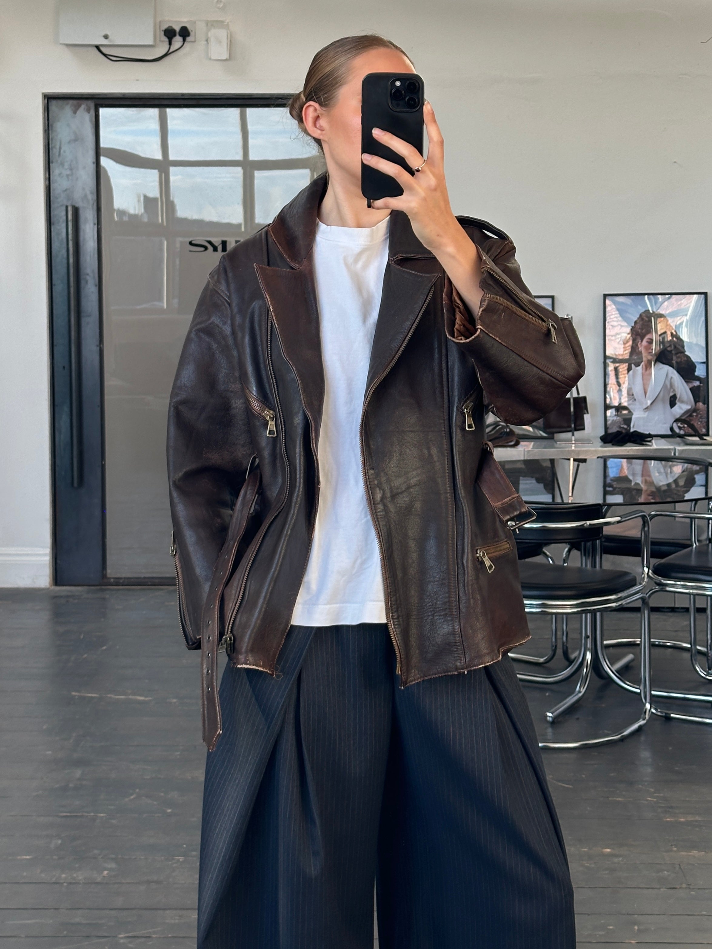 Vintage Italian 1990s belted leather jacket in size M, aged distressed leather with classic collar and button details.