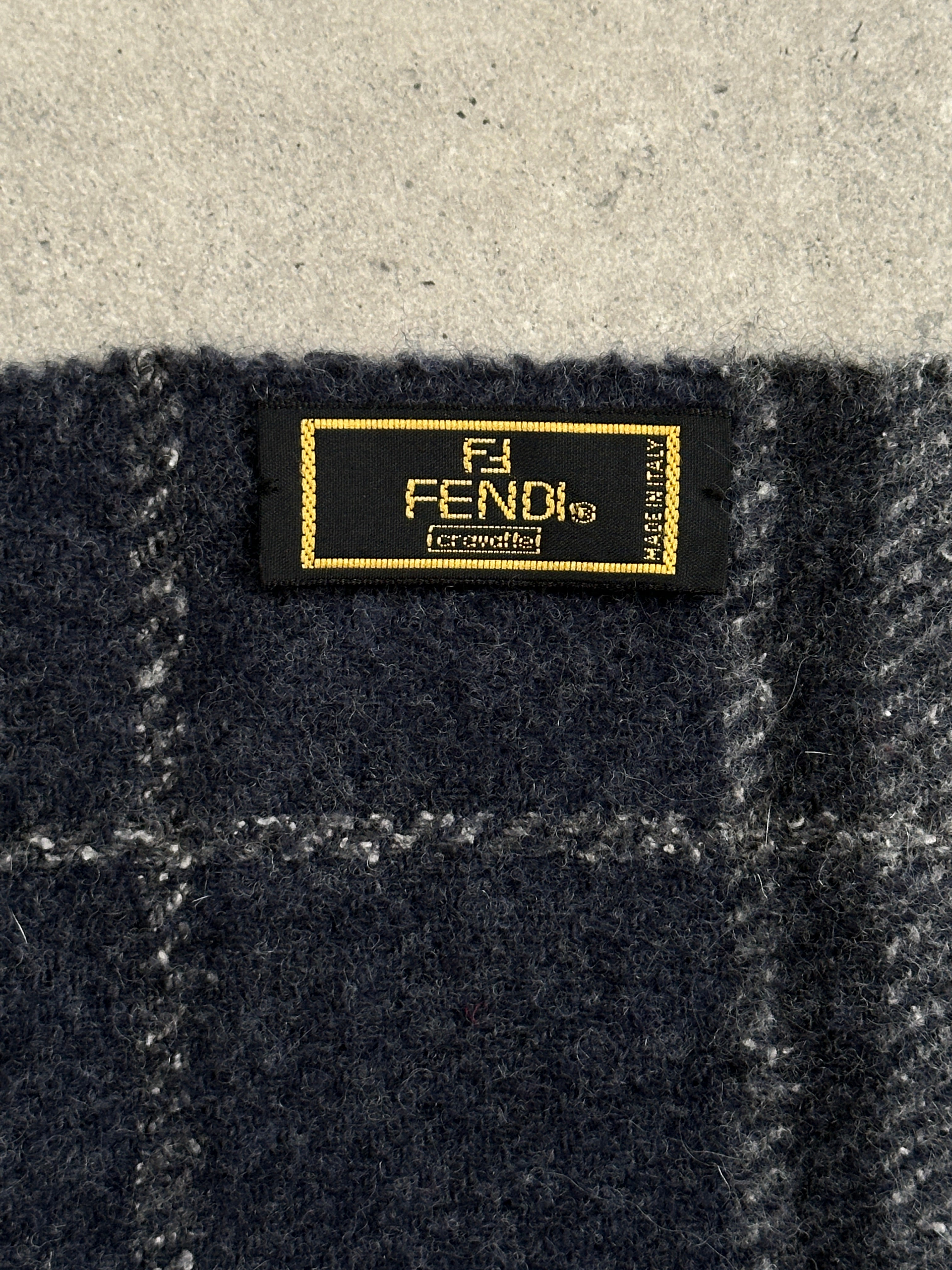Fendi pure wool logo check scarf with classic pattern, soft texture, and fringed edges, perfect for stylish cold-weather wear.