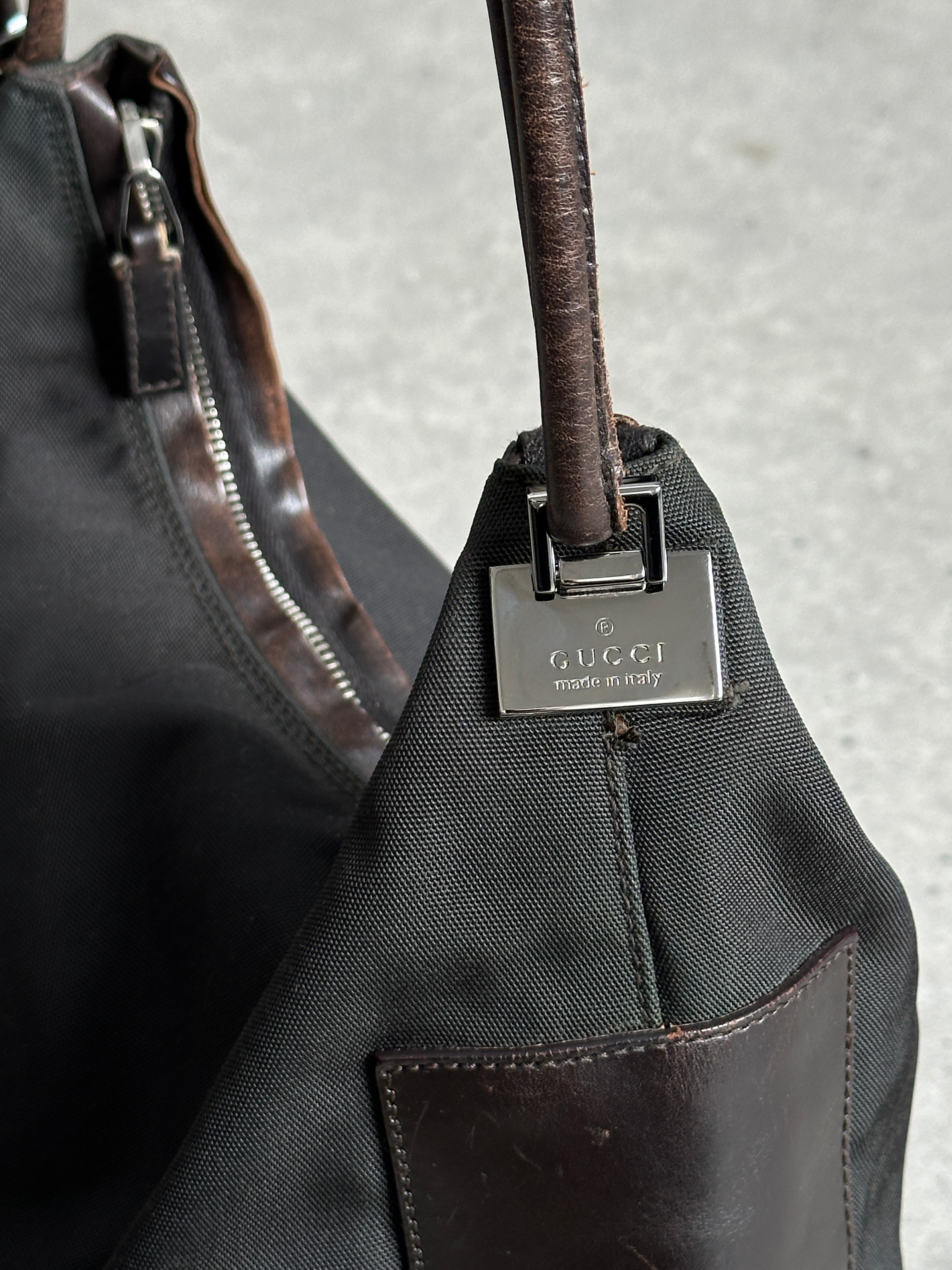 Gucci canvas and leather shoulder bag with adjustable strap and iconic design, featuring the brand's signature style.