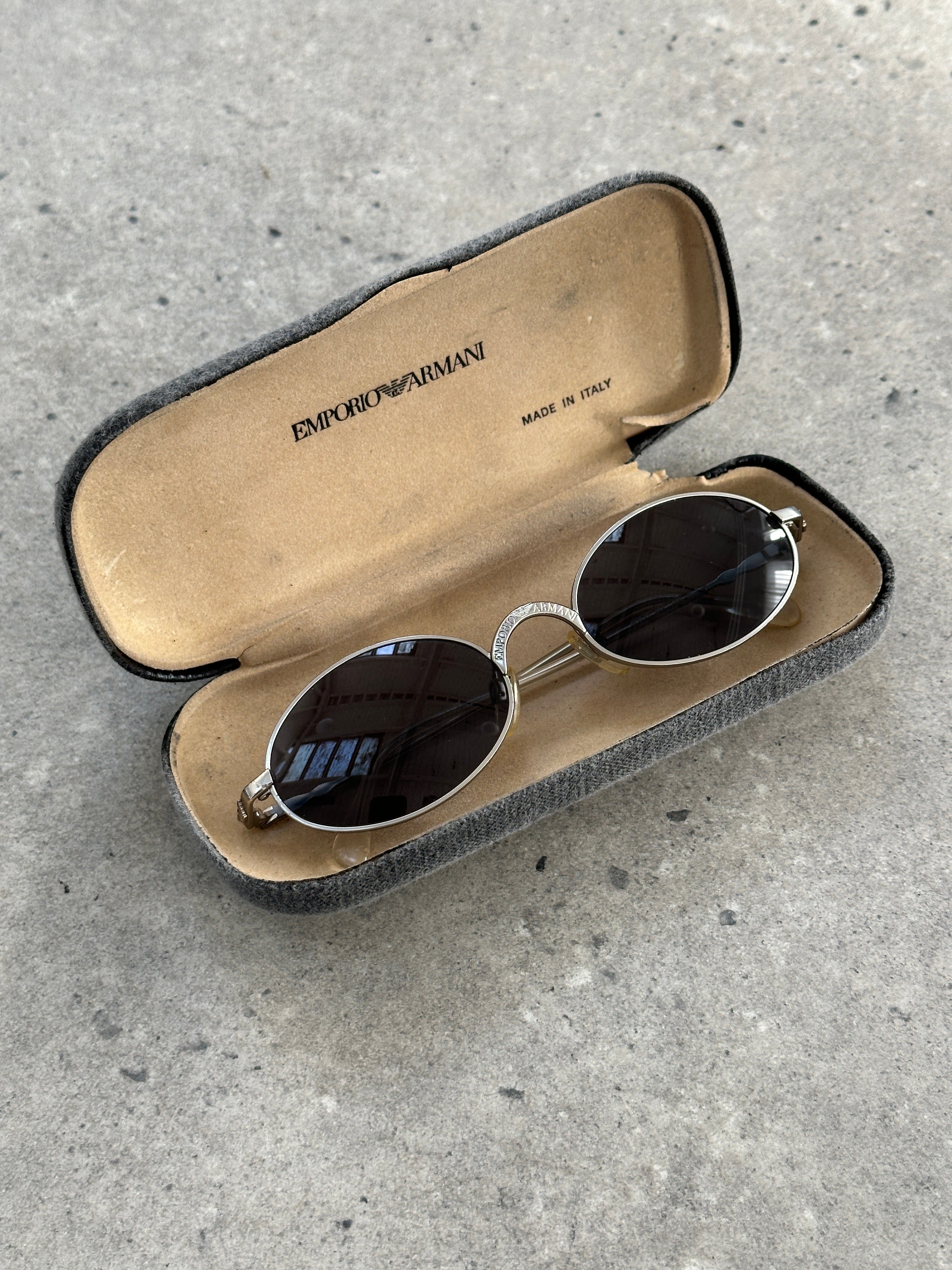 Emporio Armani metal oval sunglasses with sleek frames and dark tinted lenses, stylish and lightweight eyewear.