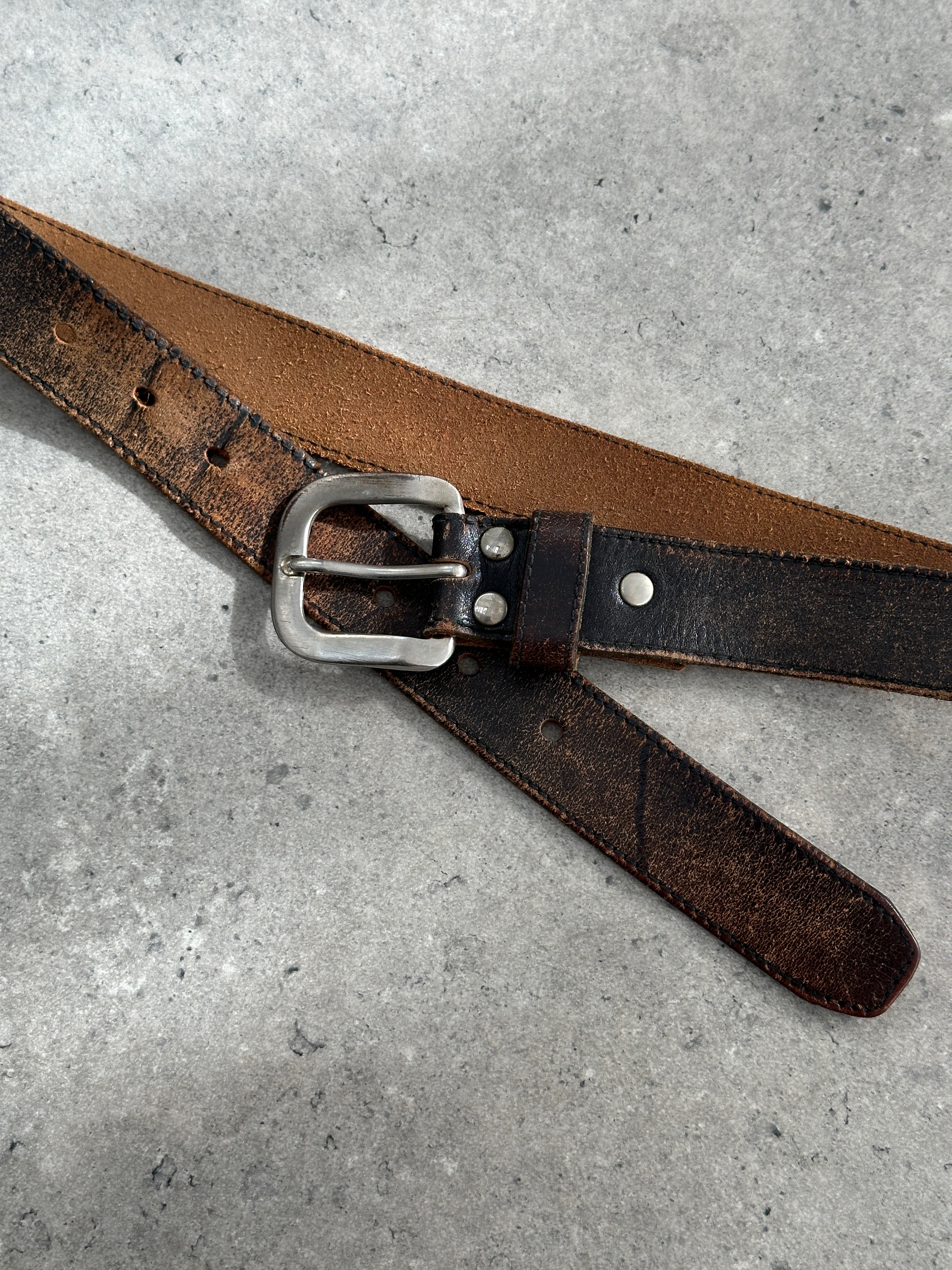 Vintage 1980s distressed leather belt with adjustable W27-35, featuring a classic buckle and rugged, worn-in leather finish.