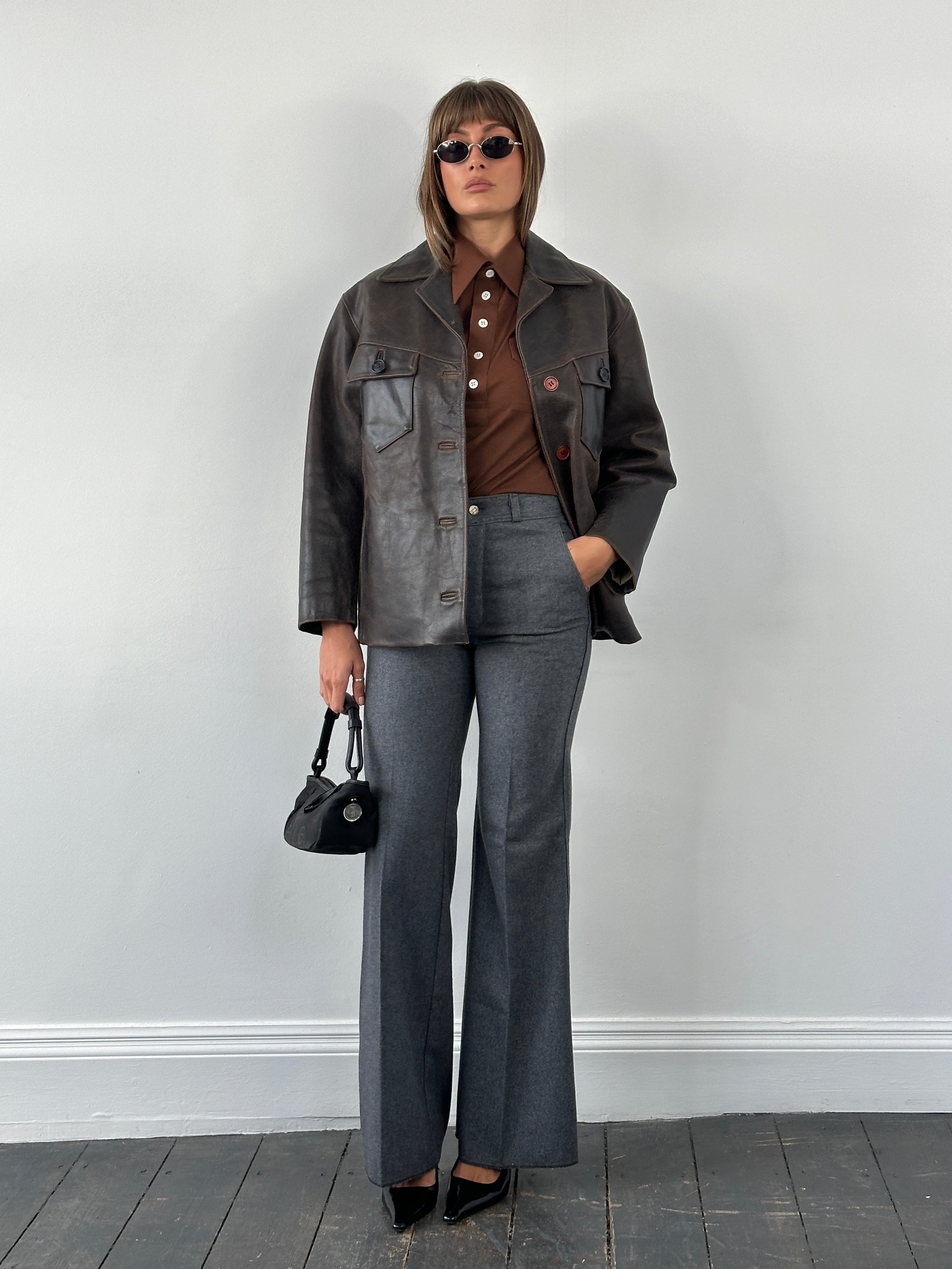Conbipel 1970s Italian aged leather jacket with classic design, displayed on a hanger, showcasing rich brown leather and vintage style.