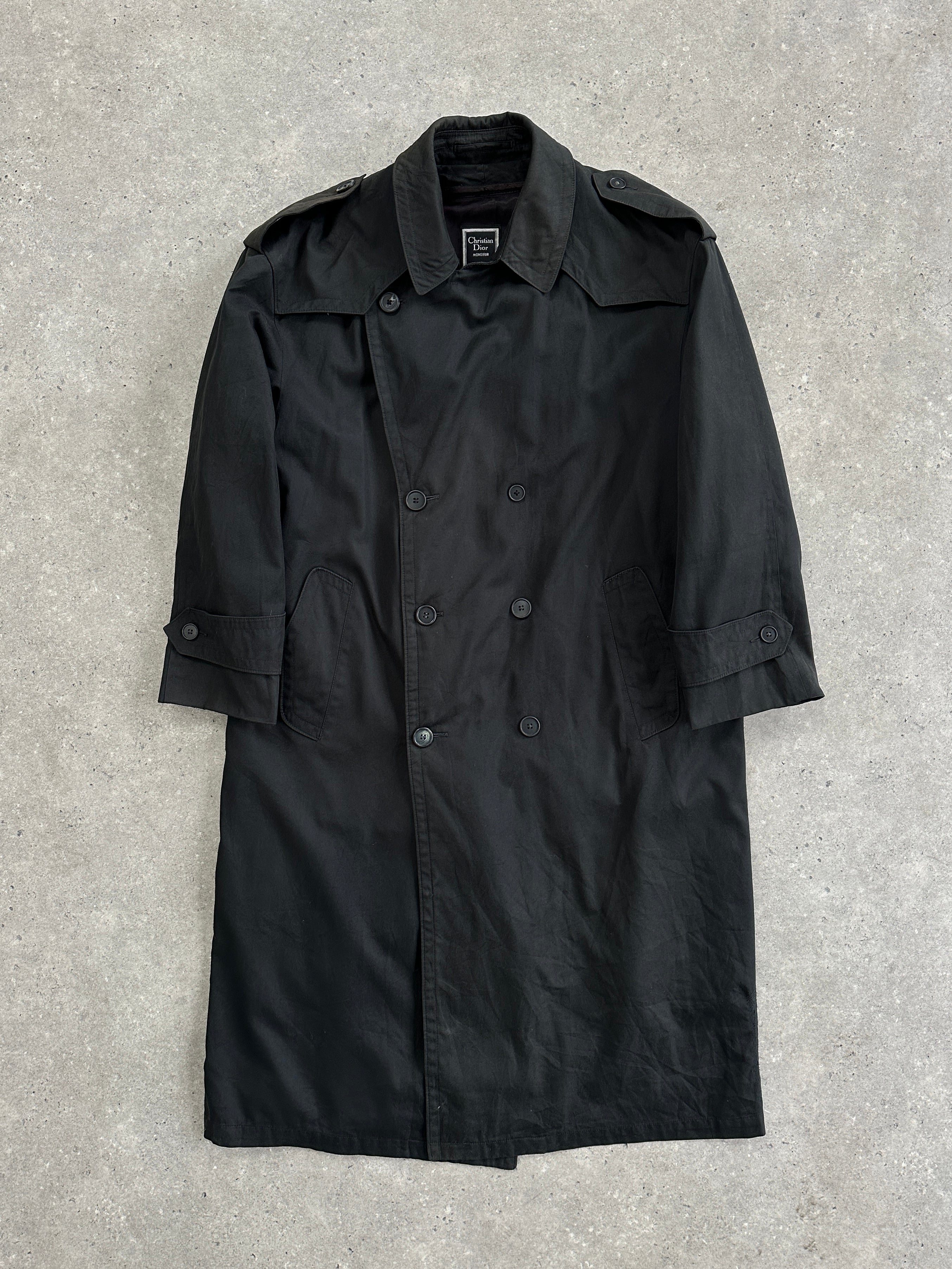 Christian Dior Monsieur double-breasted trench coat in XL displayed on a hanger, showcasing classic design and beige fabric.