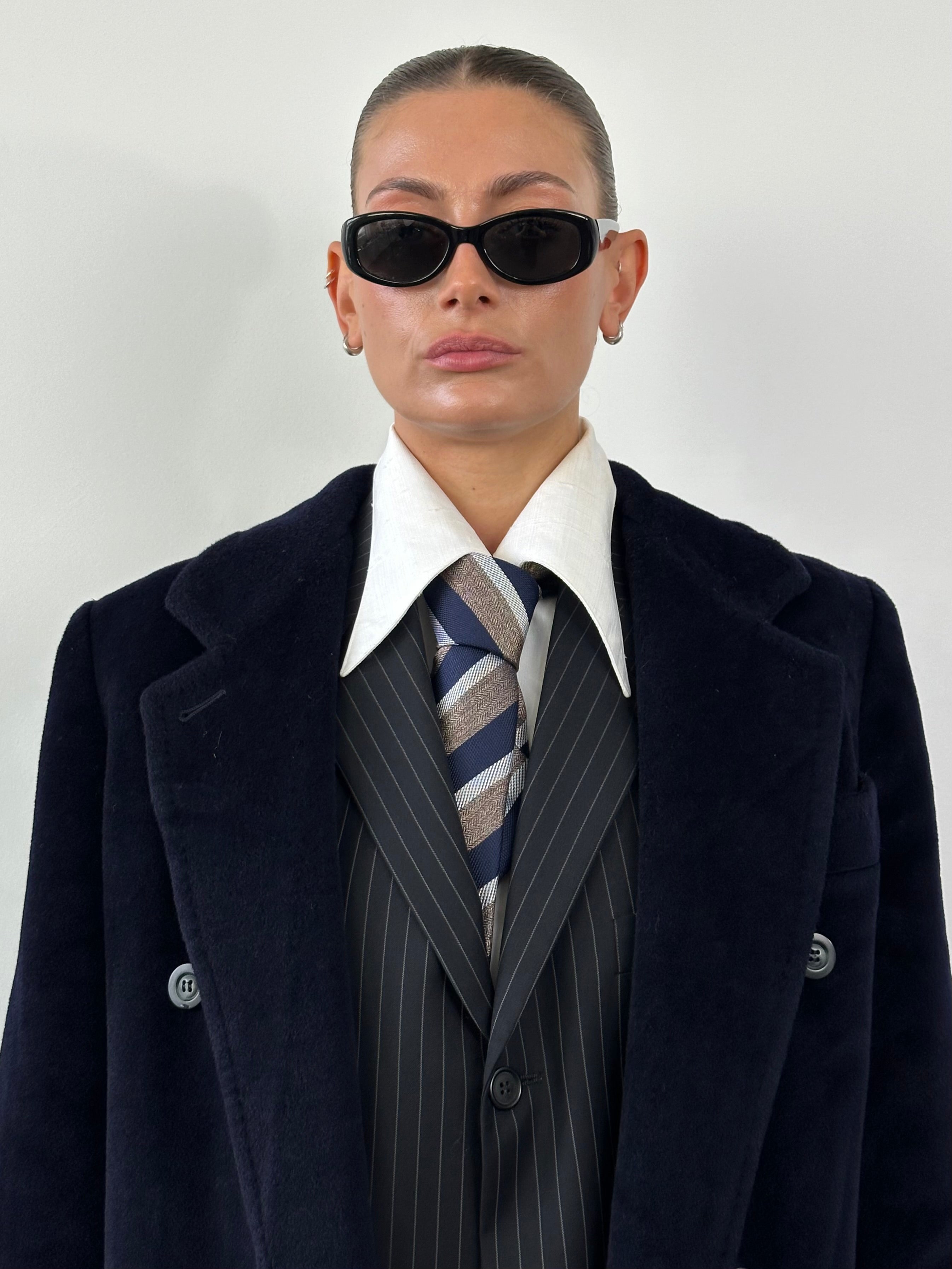 Max Mara double-breasted wool coat in classic design, displayed on a hanger with detailed fabric texture visible.