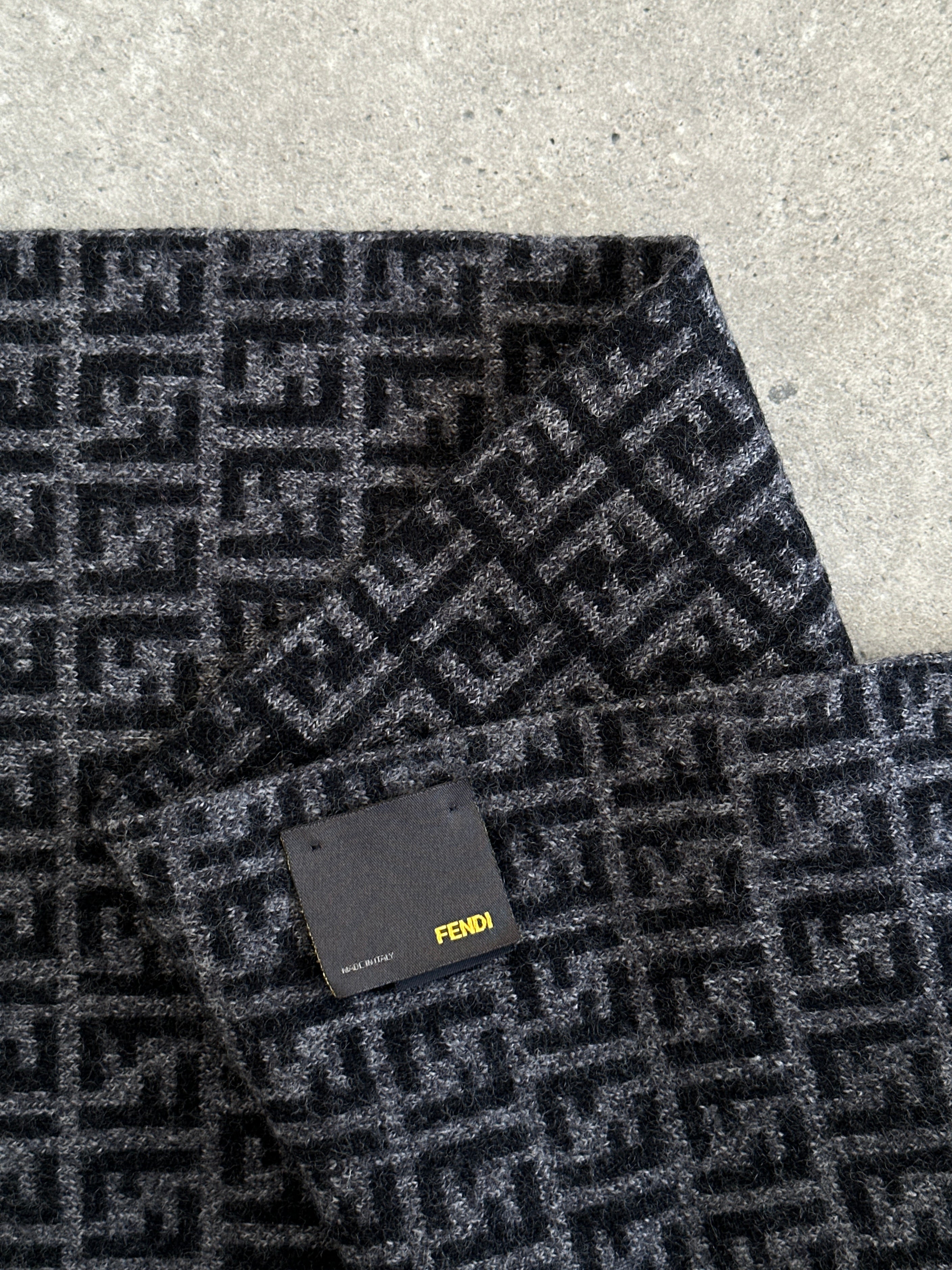 Fendi FF Monogram pure wool scarf with logo pattern and fringed edges, showcasing luxurious fabric and stylish design.