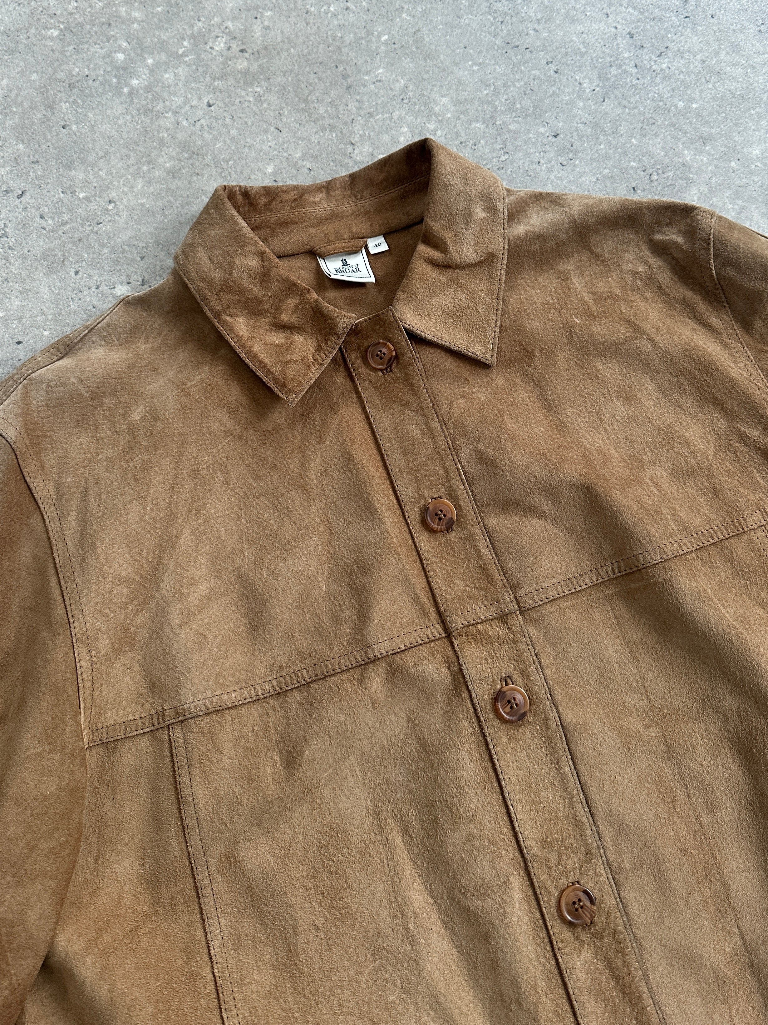 Vintage suede shirt in size large displayed on a hanger, showcasing its soft textured suede fabric and classic design.