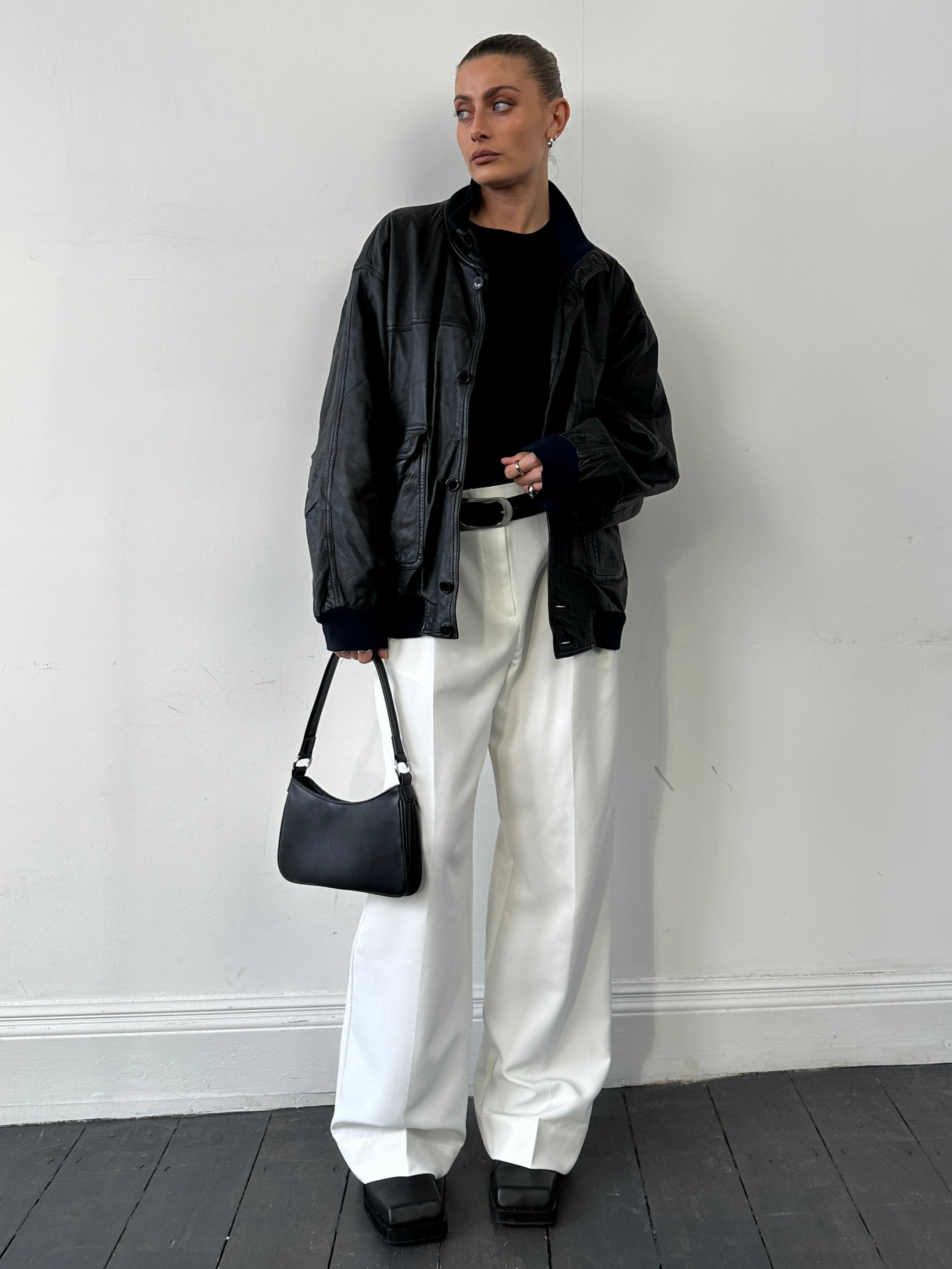 Vintage leather bomber jacket in large/extra-large size, featuring classic design and durable material, displayed on a hanger.