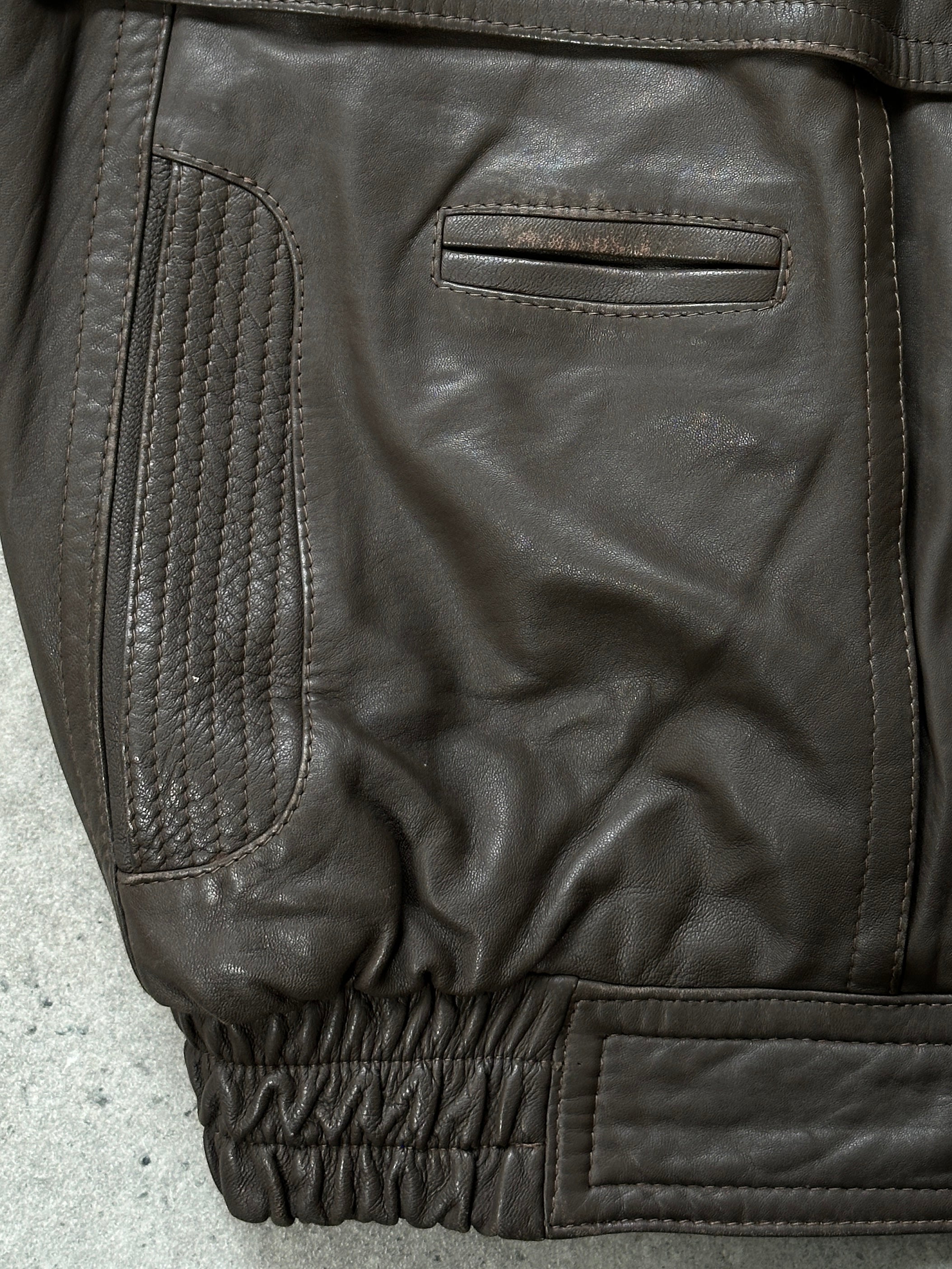 Vintage 1990s leather bomber jacket in size M, classic distressed leather with ribbed cuffs and collar, casual style.