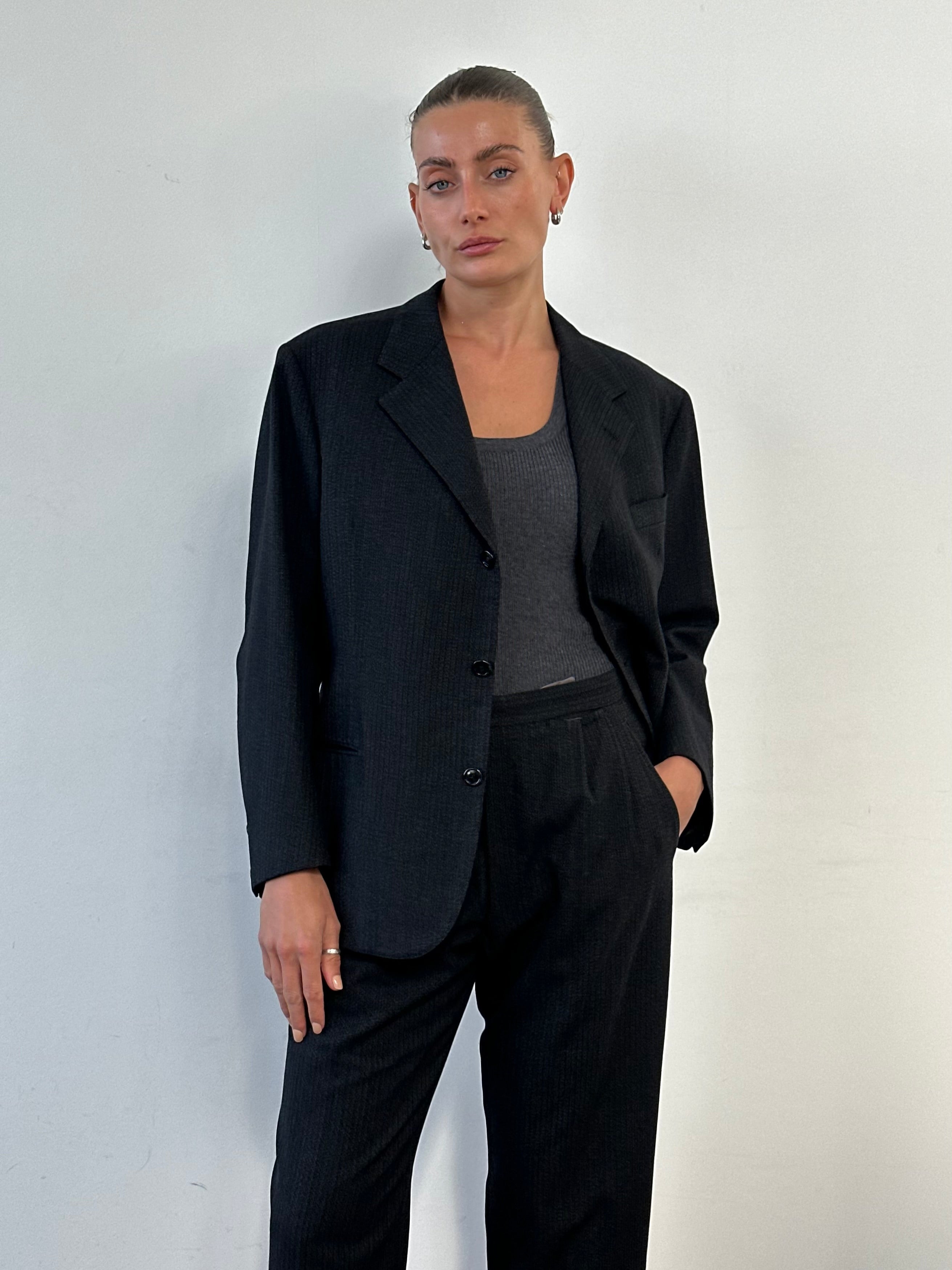 Vintage wool single-breasted suit in size 40R/W28, featuring classic tailored details and a timeless design.