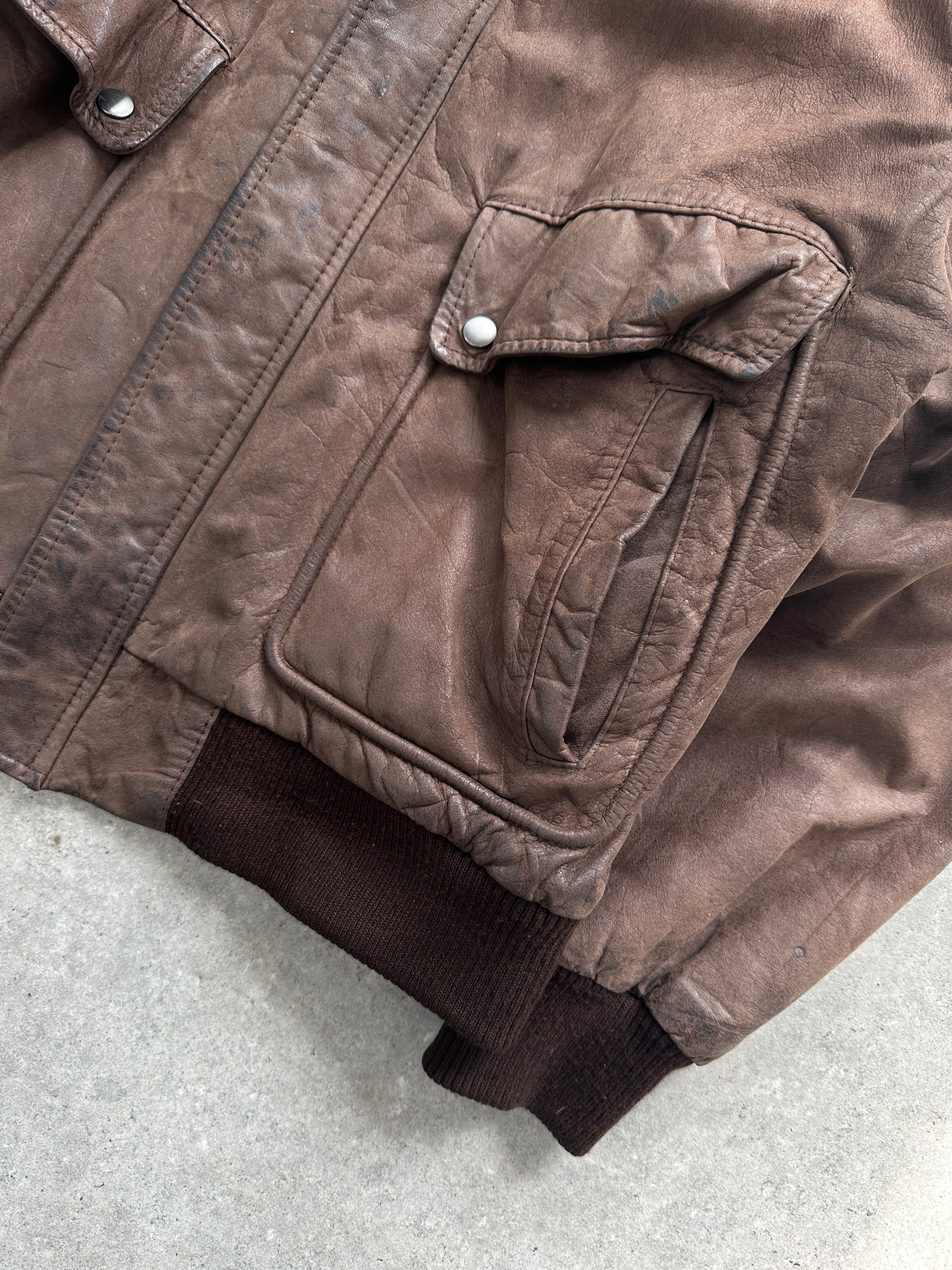 Vintage distressed leather bomber jacket in size large, featuring a rugged design and classic collar.