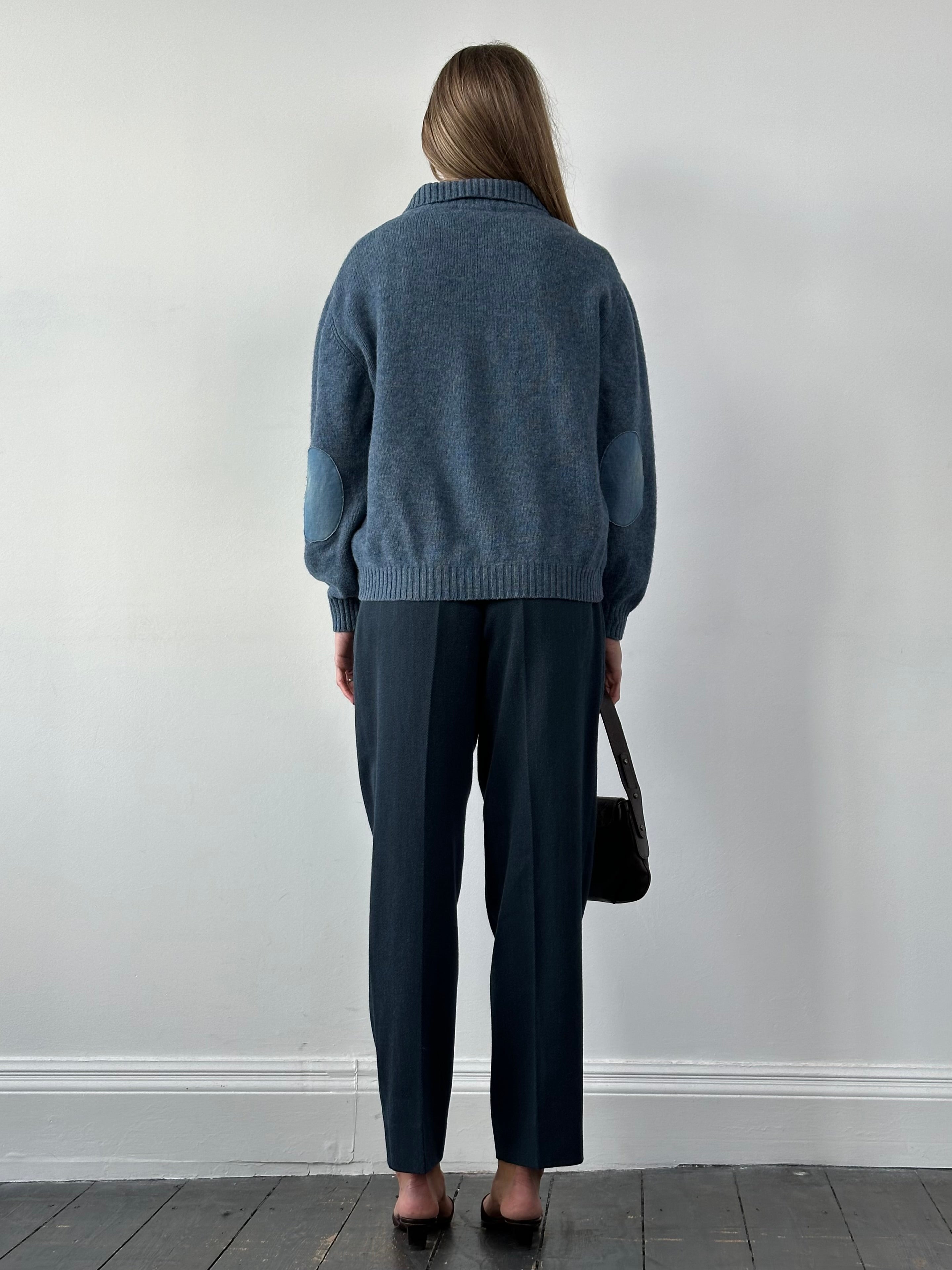 Vintage Italian high-waisted tailored wool trousers in classic design, shown in a natural pose on a plain background.