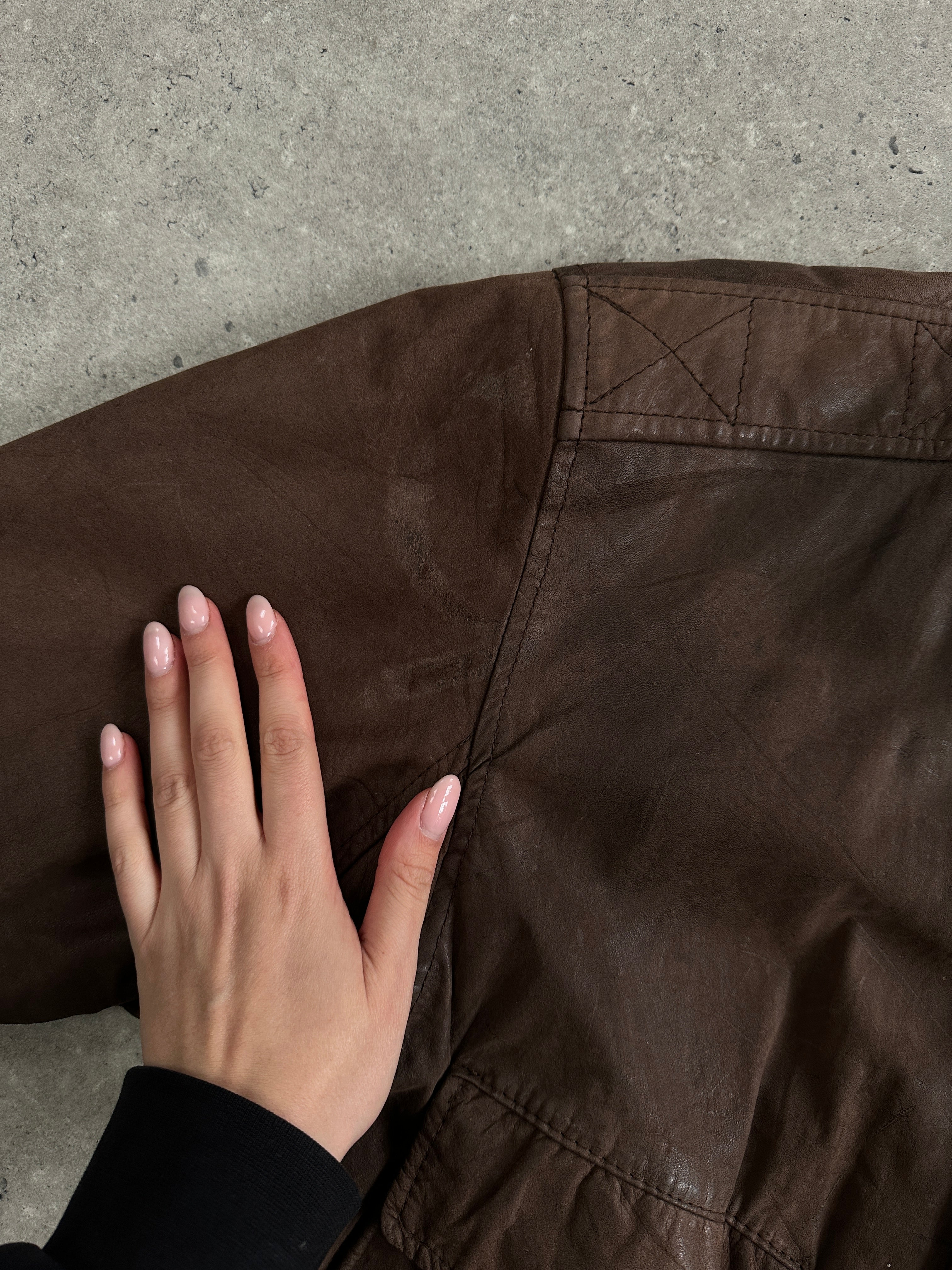 Vintage leather bomber jacket in size L, featuring classic design with a rugged leather exterior and detailed stitching.
