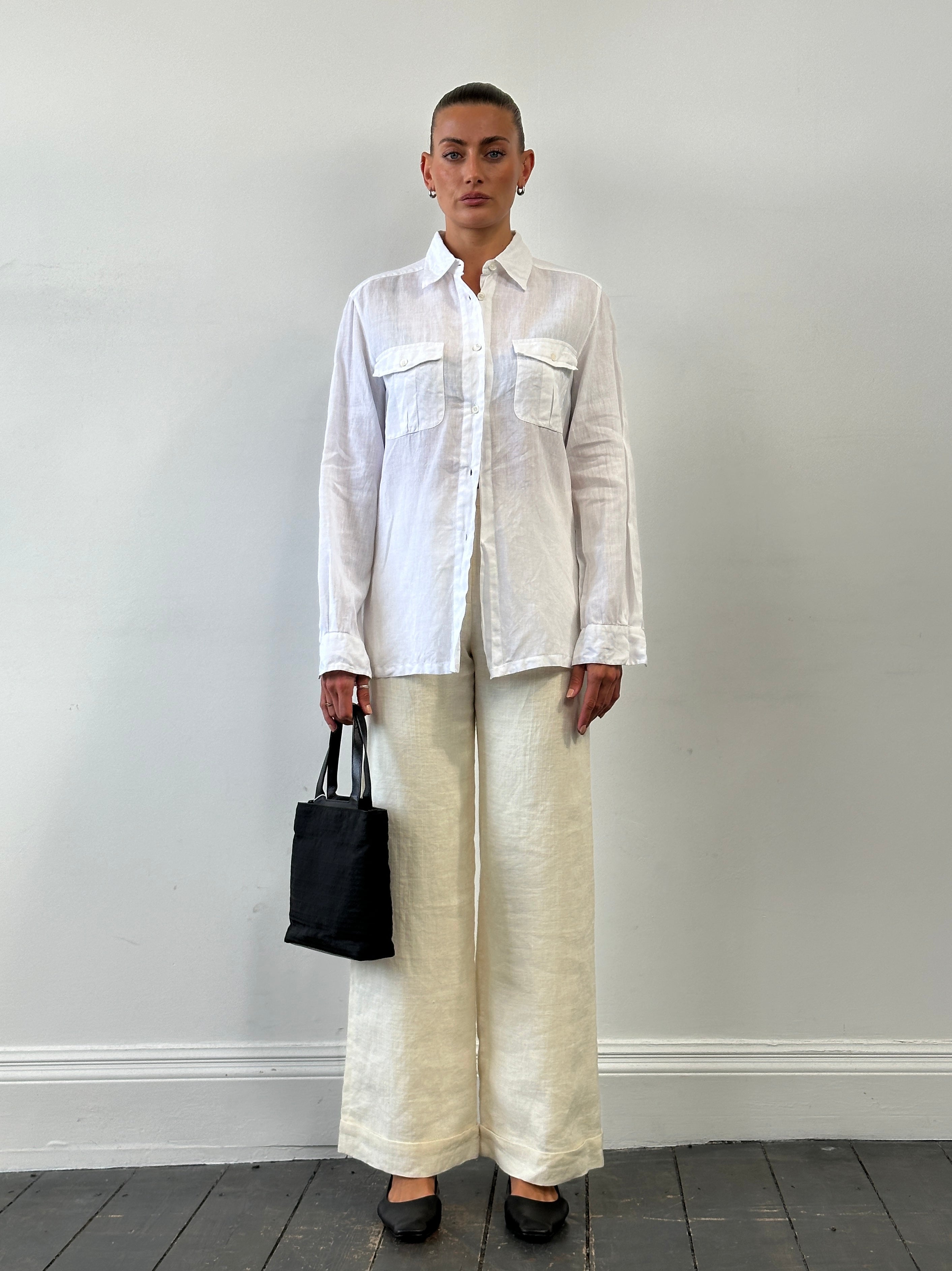 Vintage high waisted wide leg tailored trousers in dark fabric, showing the relaxed fit and classic design.