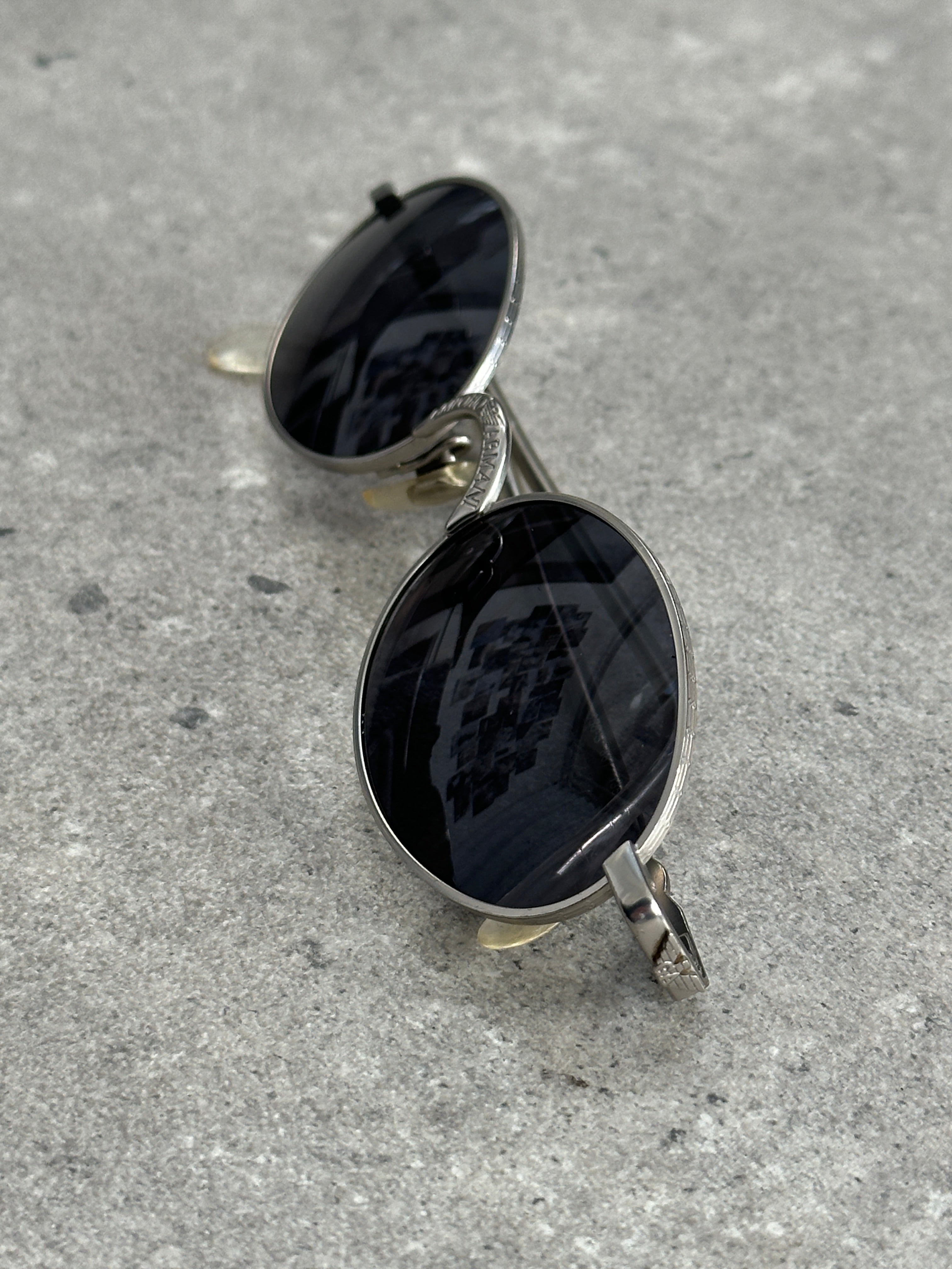 Emporio Armani metal oval sunglasses with sleek frame and tinted lenses, stylish accessories for sun protection and fashion.