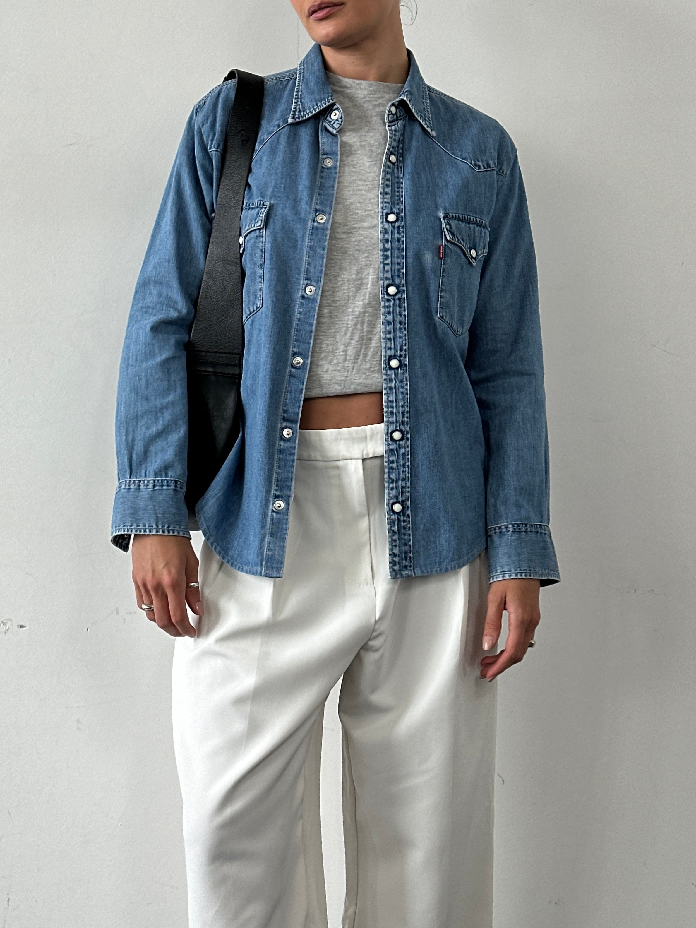 Levi’s cotton denim button-up shirt in size medium, featuring classic blue denim fabric and button front design.