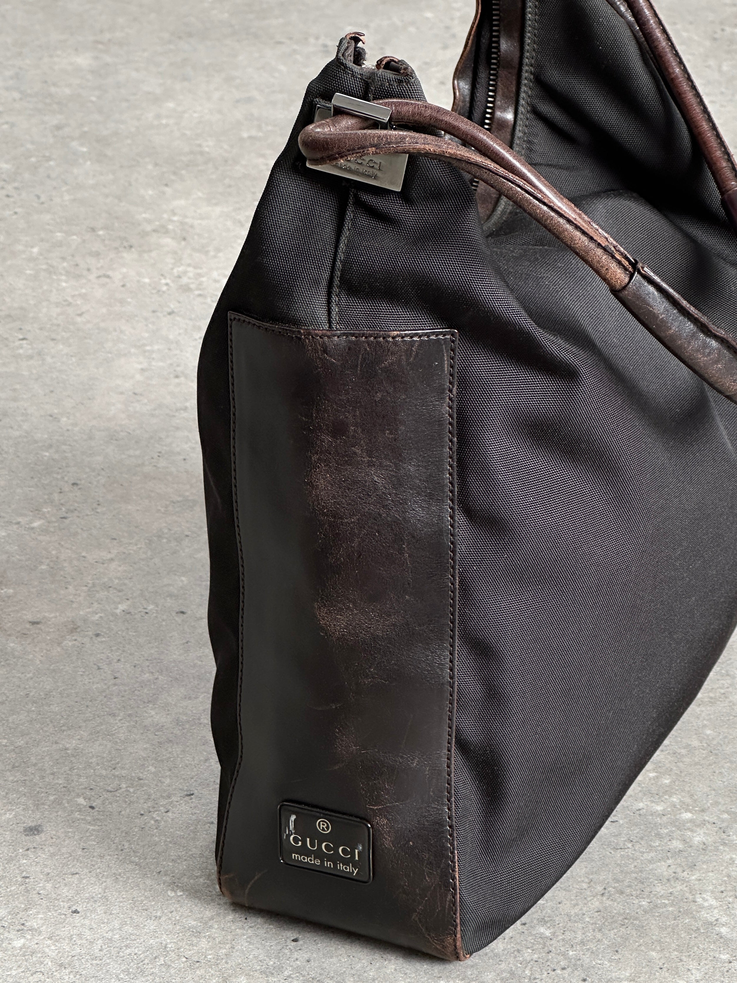 Gucci canvas and leather shoulder bag with adjustable strap and signature Gucci logo design.