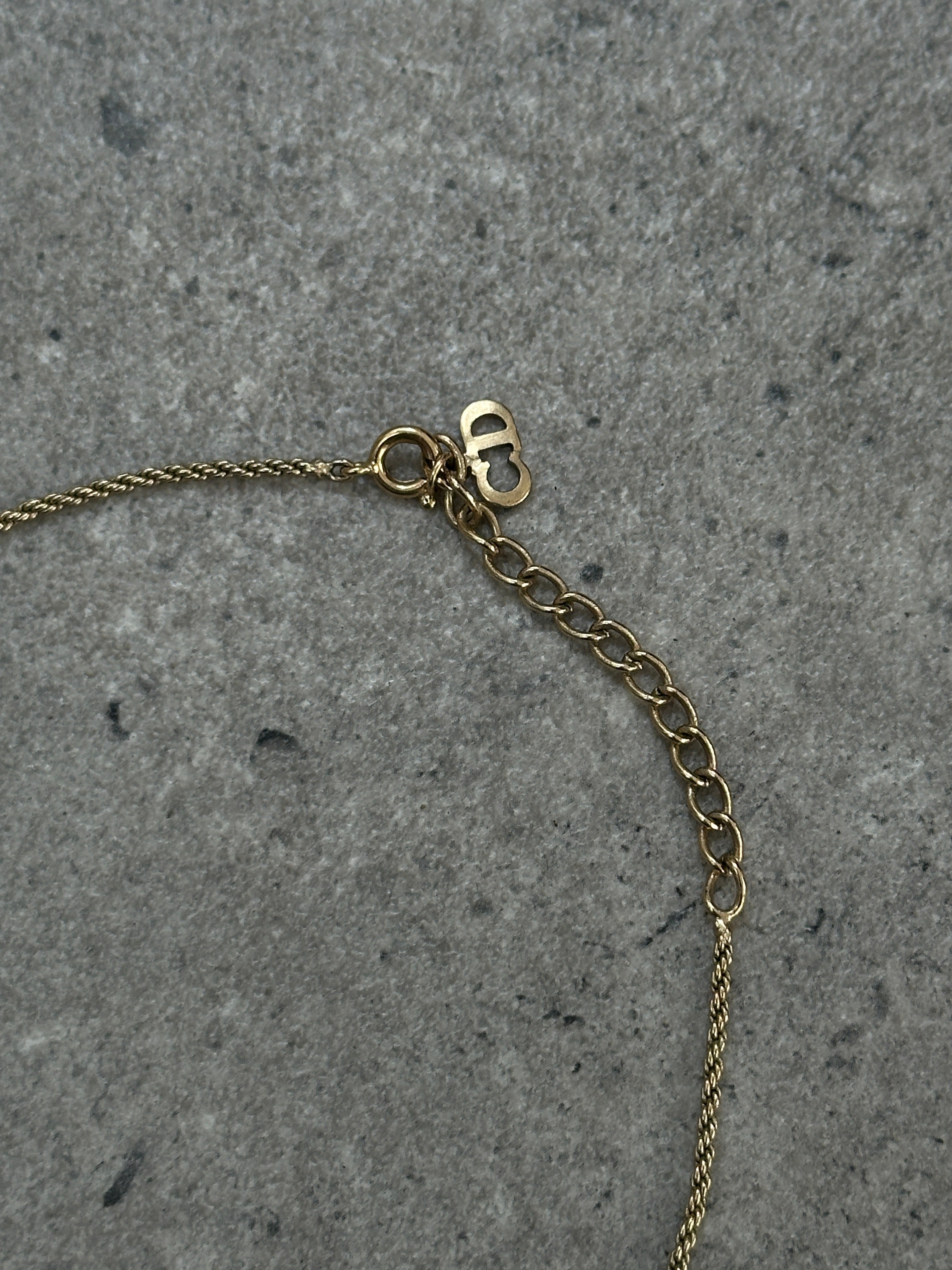 Christian Dior 16-inch gold-plated rhinestone logo pendant necklace showing the sparkling Dior emblem.