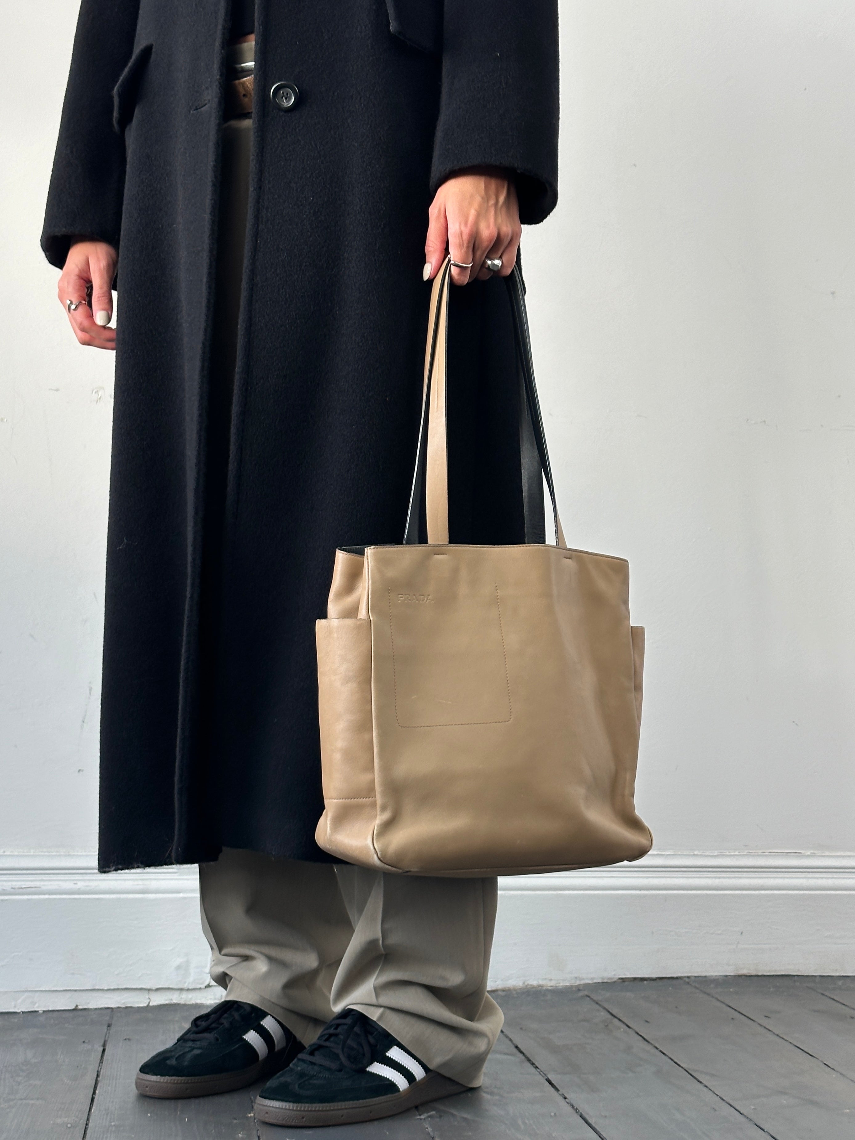 Prada contrast leather tote bag with sleek design, featuring two handles and a spacious interior for everyday use.