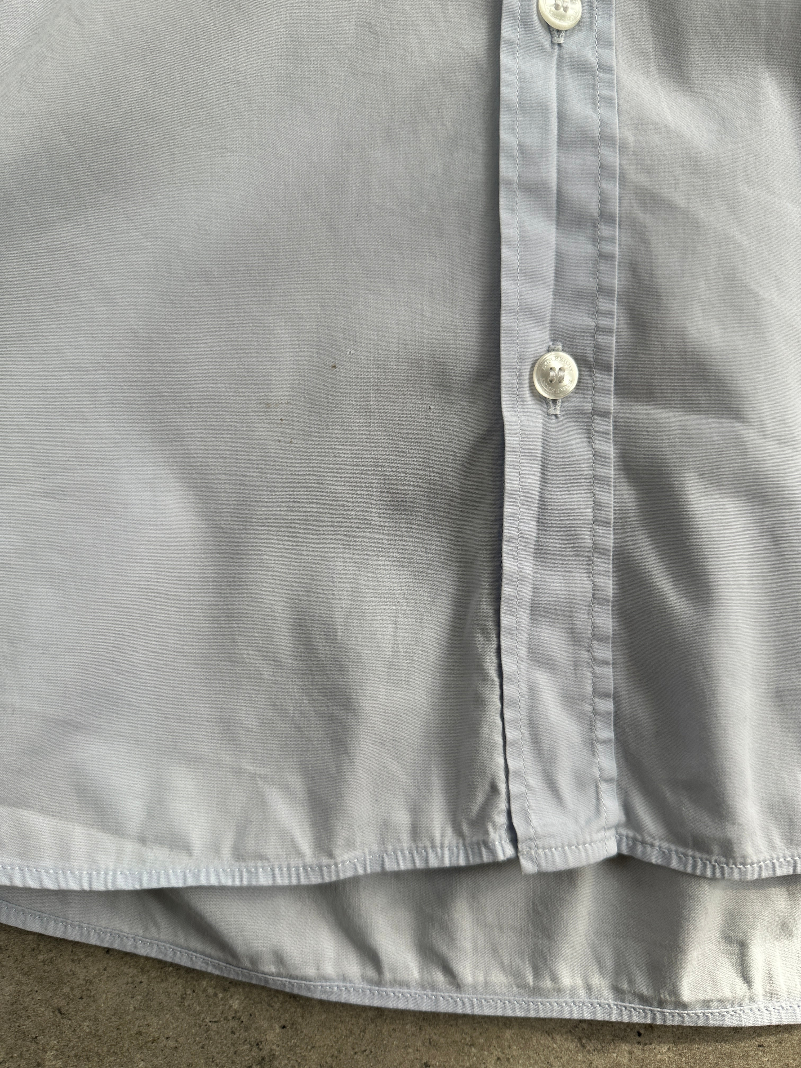 Burberry Brit cotton logo shirt in size M, featuring the classic logo design, displayed on a hanger against a neutral background.