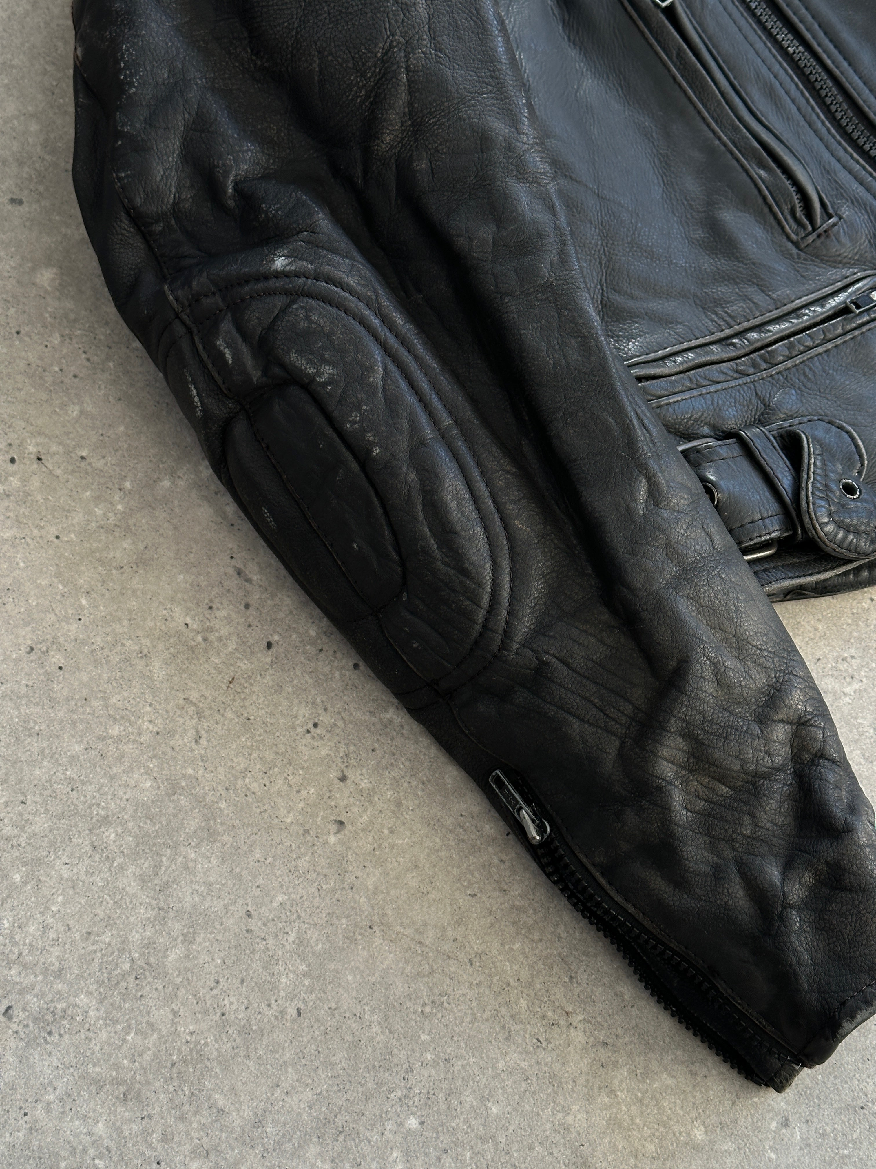 Vintage structured motorcycle leather jacket in size L/XL with classic design and detailed stitching.