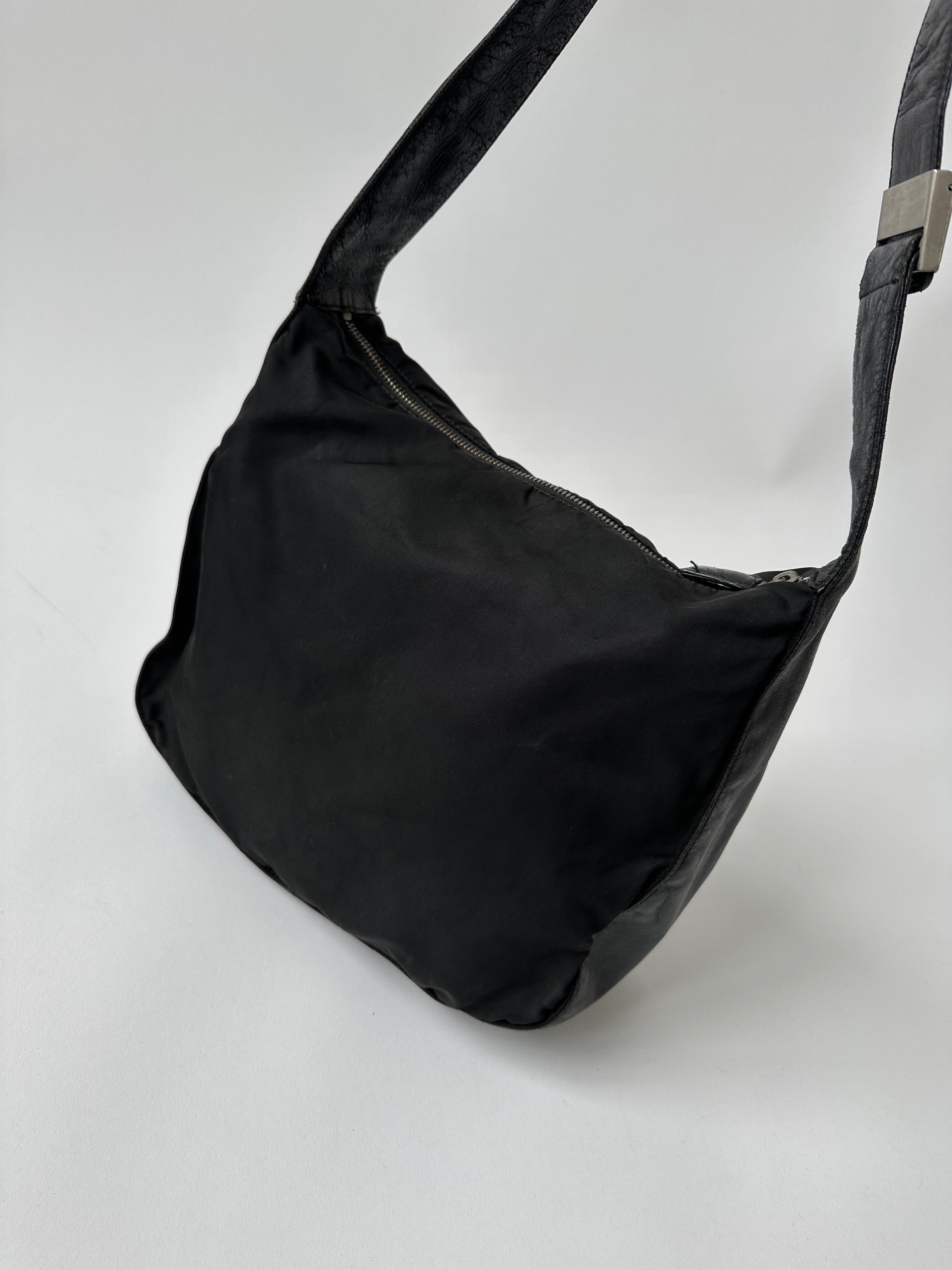 Prada nylon and leather crossbody bag with adjustable strap and sleek design, perfect for everyday use.