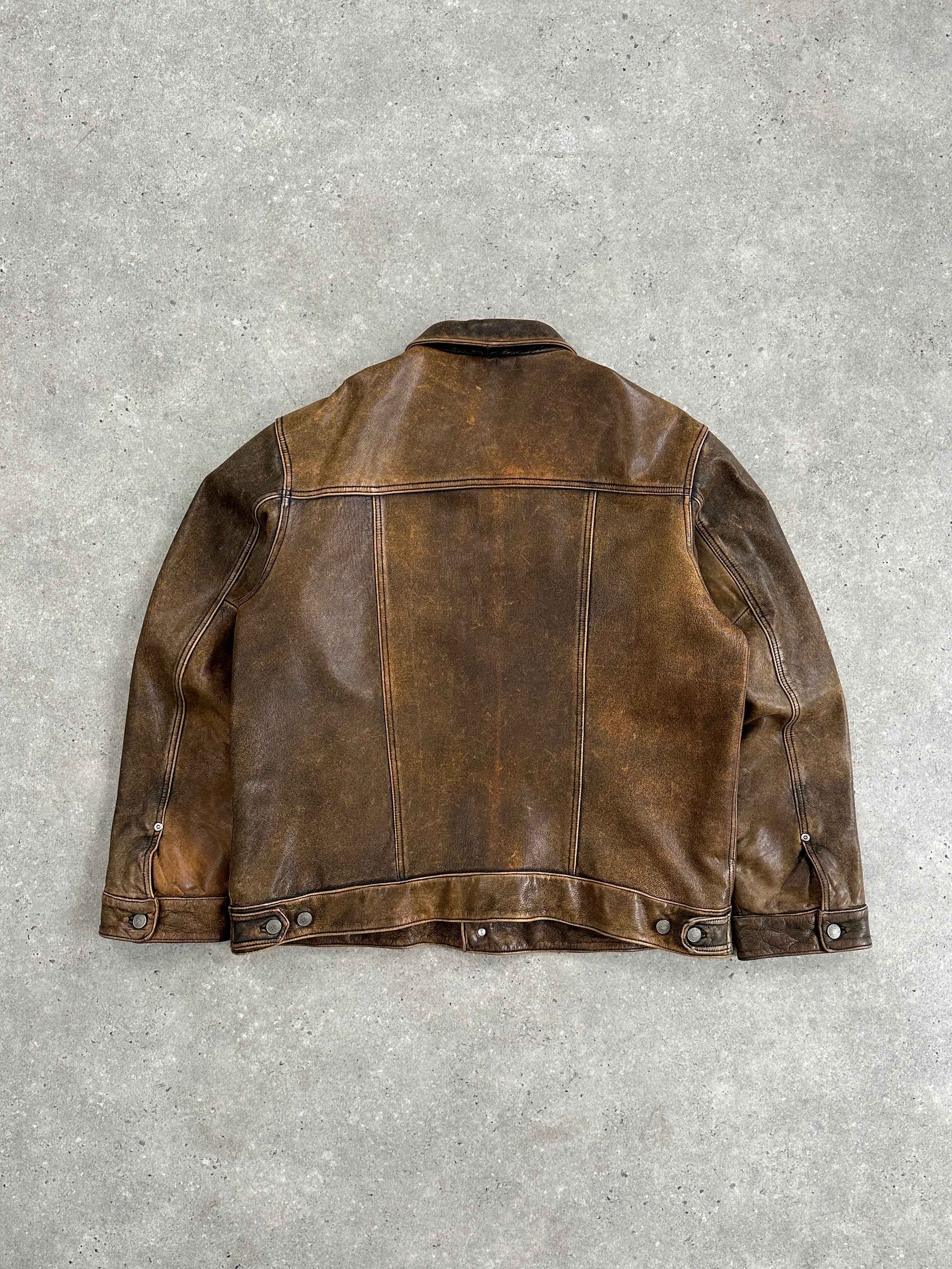 Vintage aged leather trucker jacket in XL size, featuring classic design and rugged texture, displayed on a hanger.