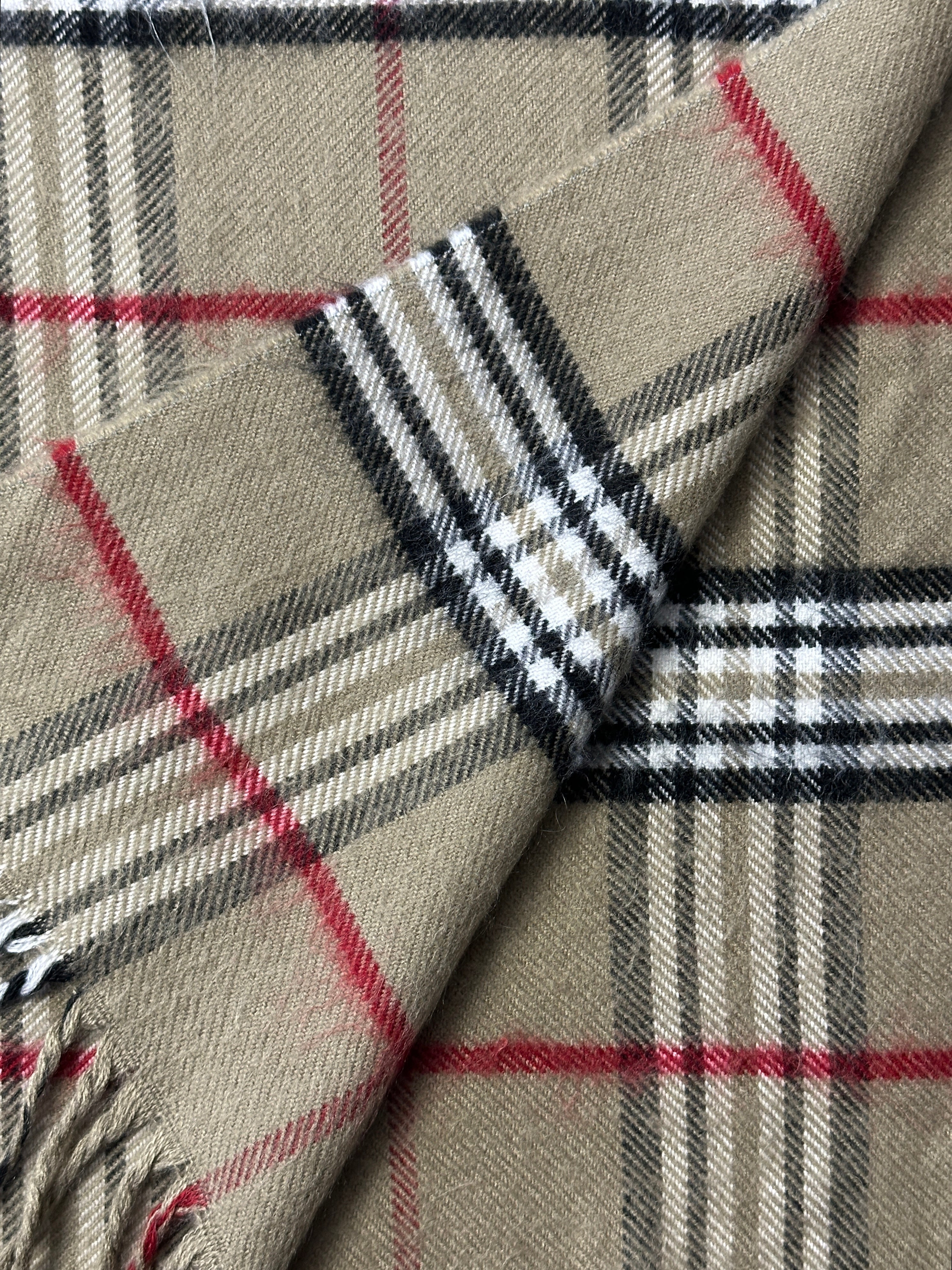 Vintage check tassel scarf featuring a classic pattern and fringed edges, perfect for stylish accessories.