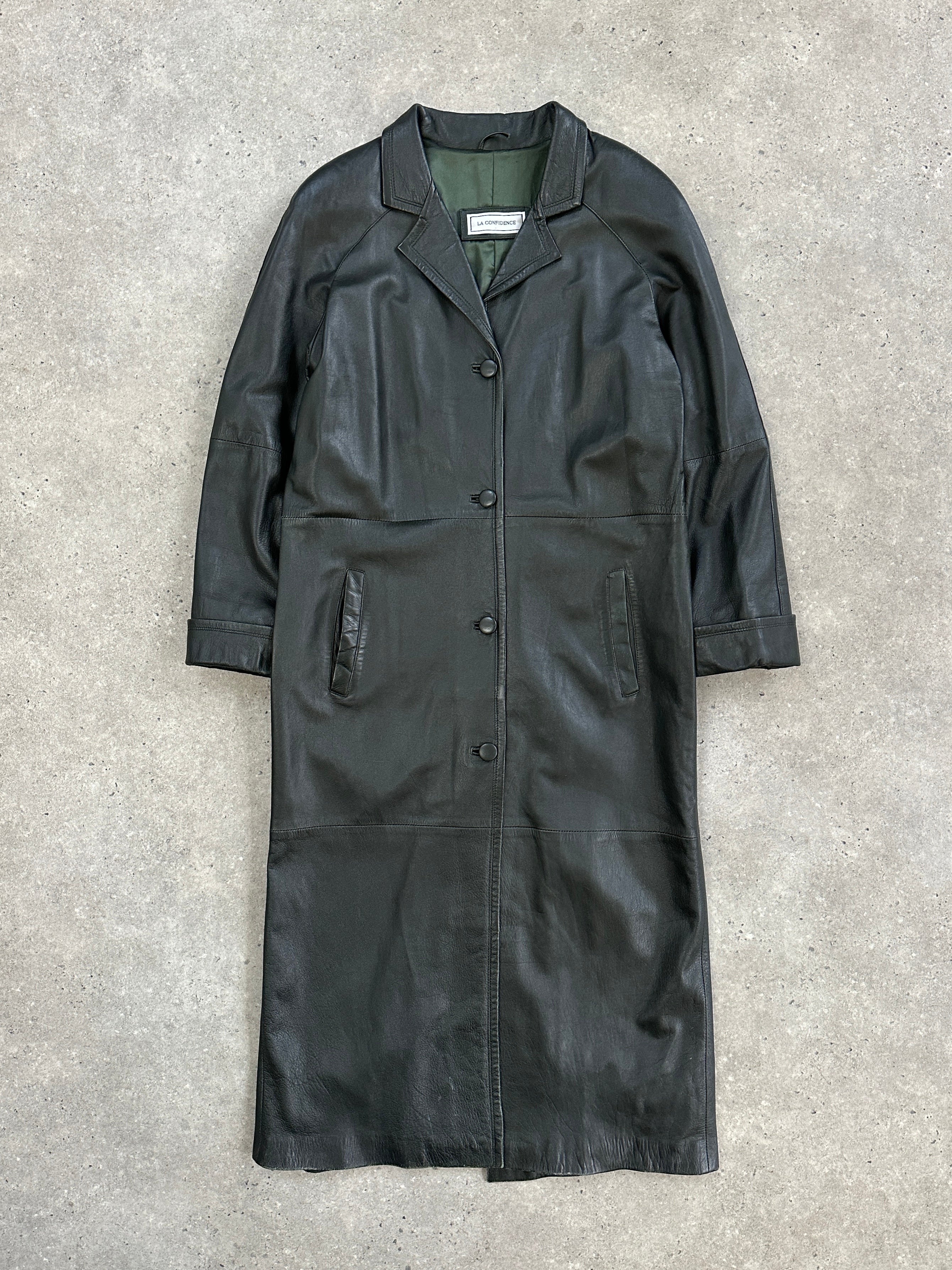 Vintage 1990s leather trench coat jacket in floor length style, shown hanging on a mannequin, showcasing its classic design and rich texture.