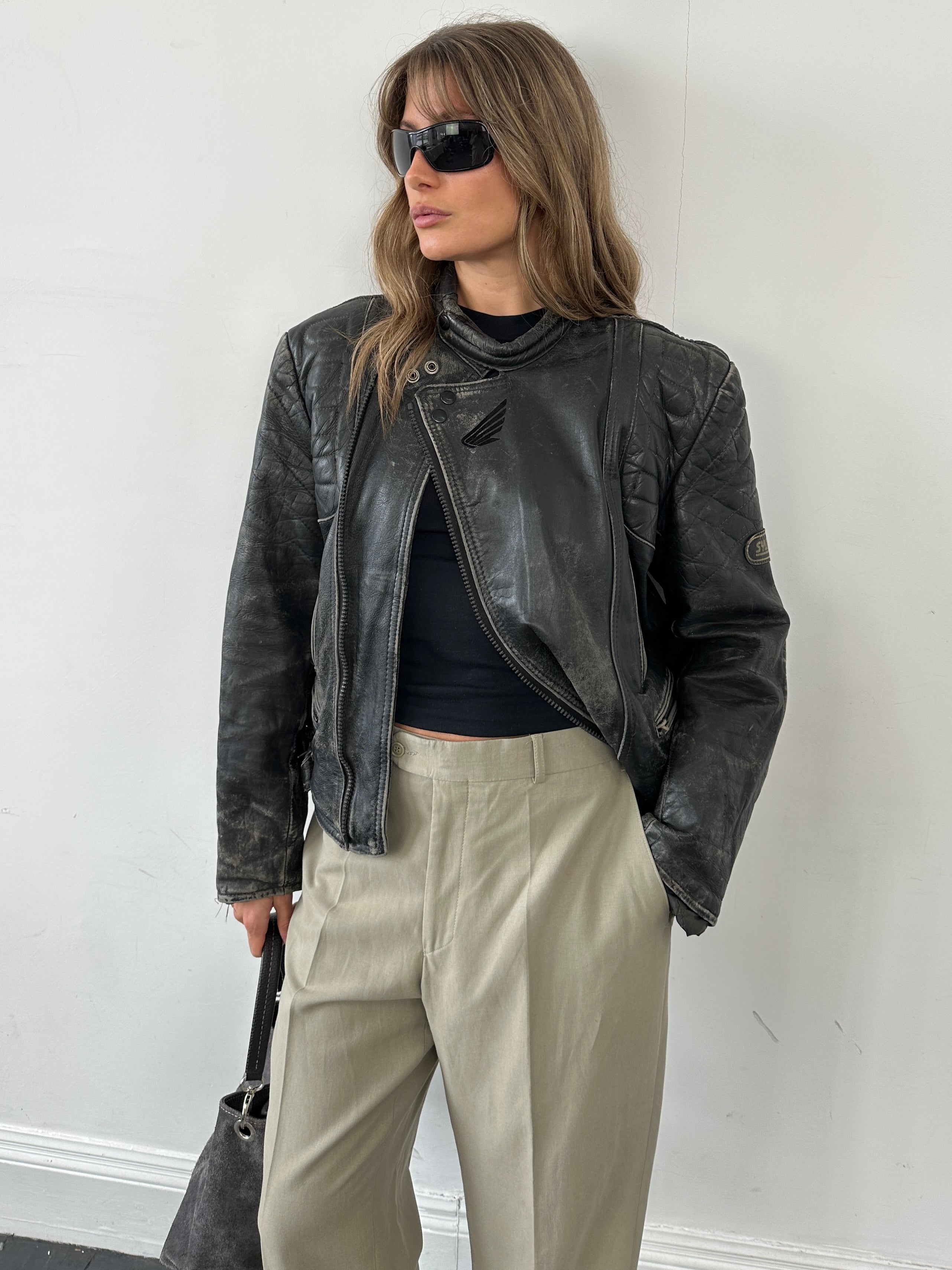 Vintage brand distressed leather motorcycle jacket in size M/L, featuring rugged design and classic style.