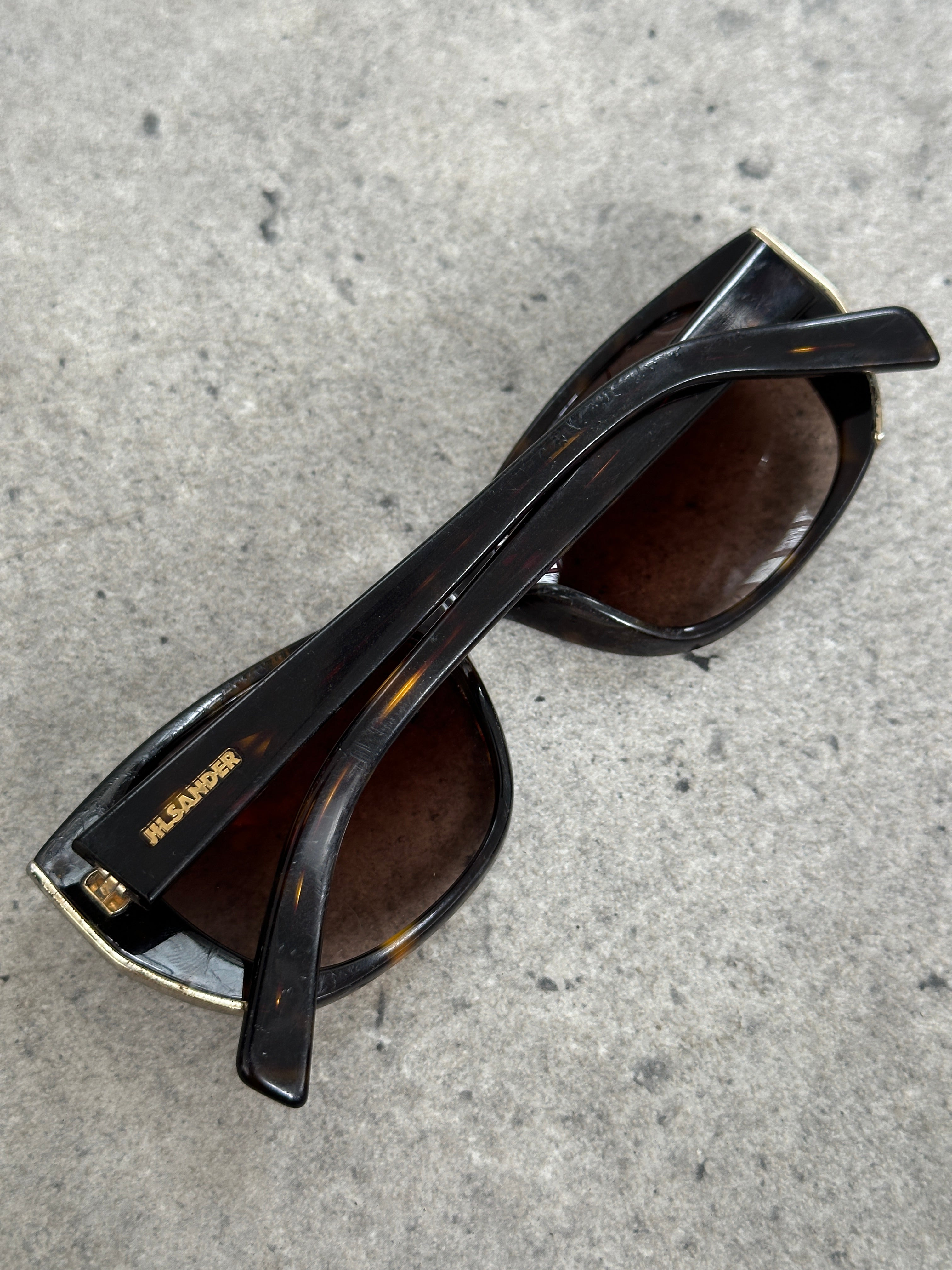 Jil Sander tortoiseshell rectangular logo sunglasses with dark lenses and bold frame, vintage 2000s style.