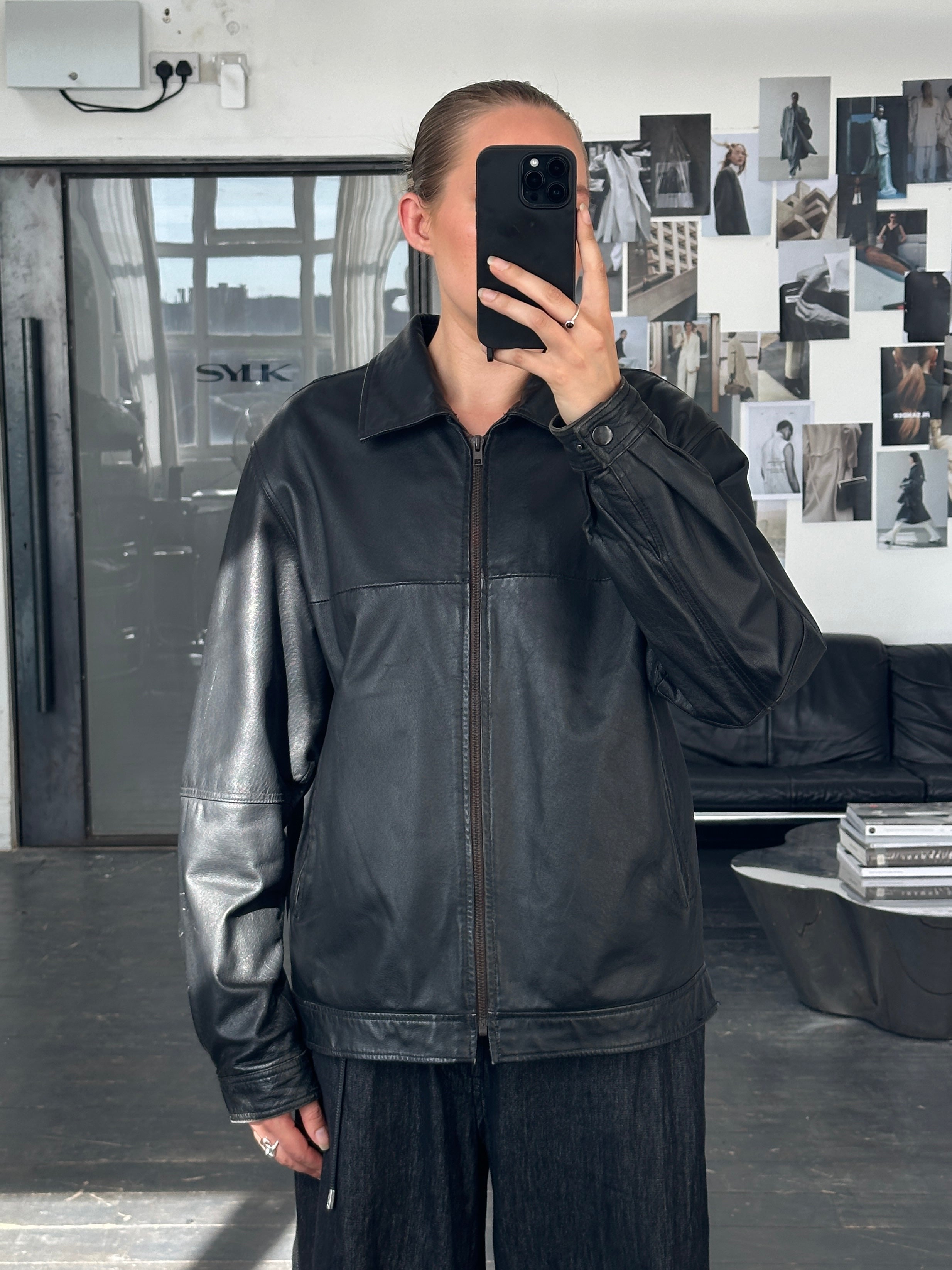 Vintage 1990s minimal leather jacket in size L/XL, classic black leather with sleek design and minimal detailing.