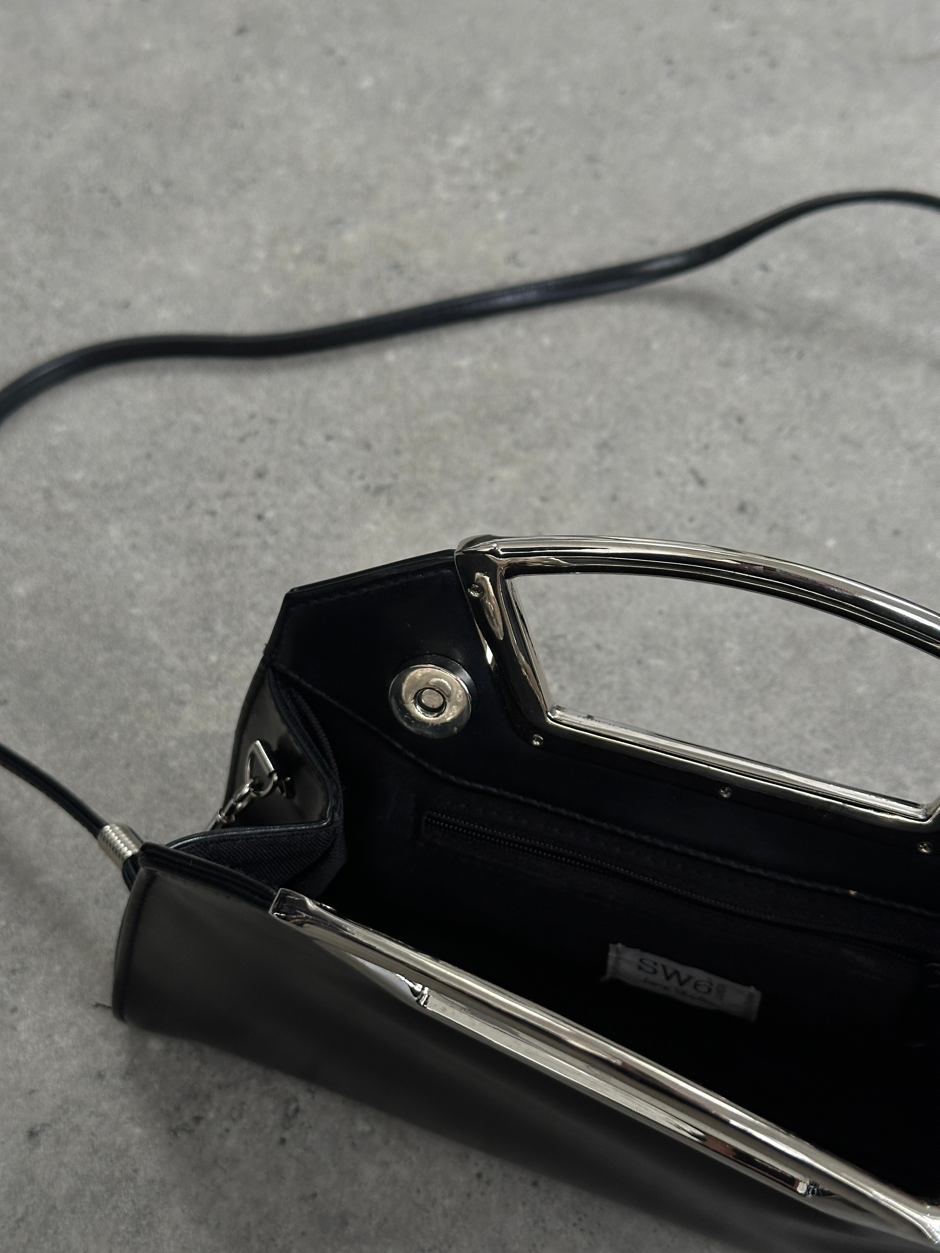 Vintage leather chrome crossbody clutch bag with adjustable strap and classic design, perfect for stylish everyday use.