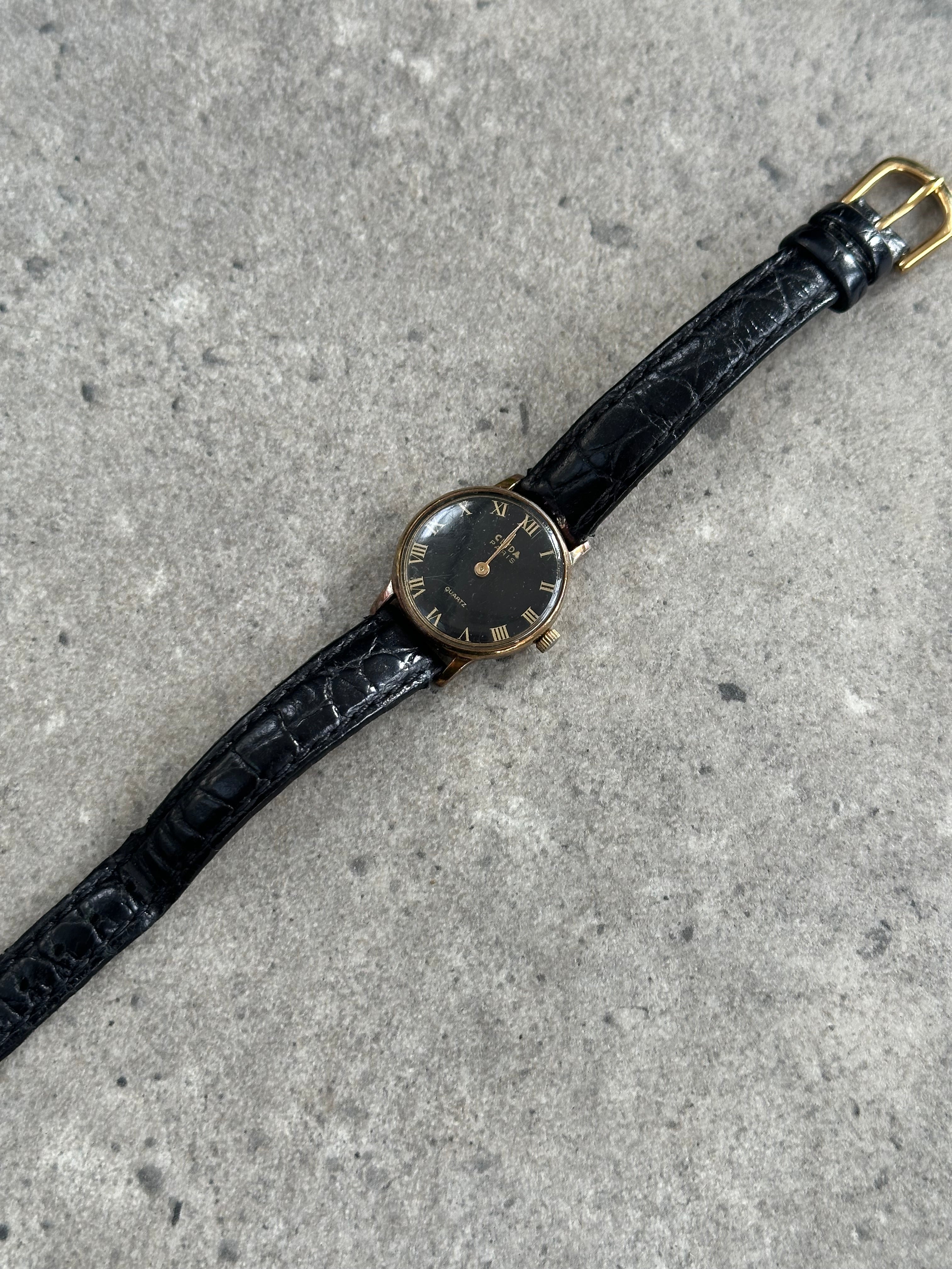 Vintage 1990s round quartz leather watch with a classic design and leather strap, featuring a vintage aesthetic.