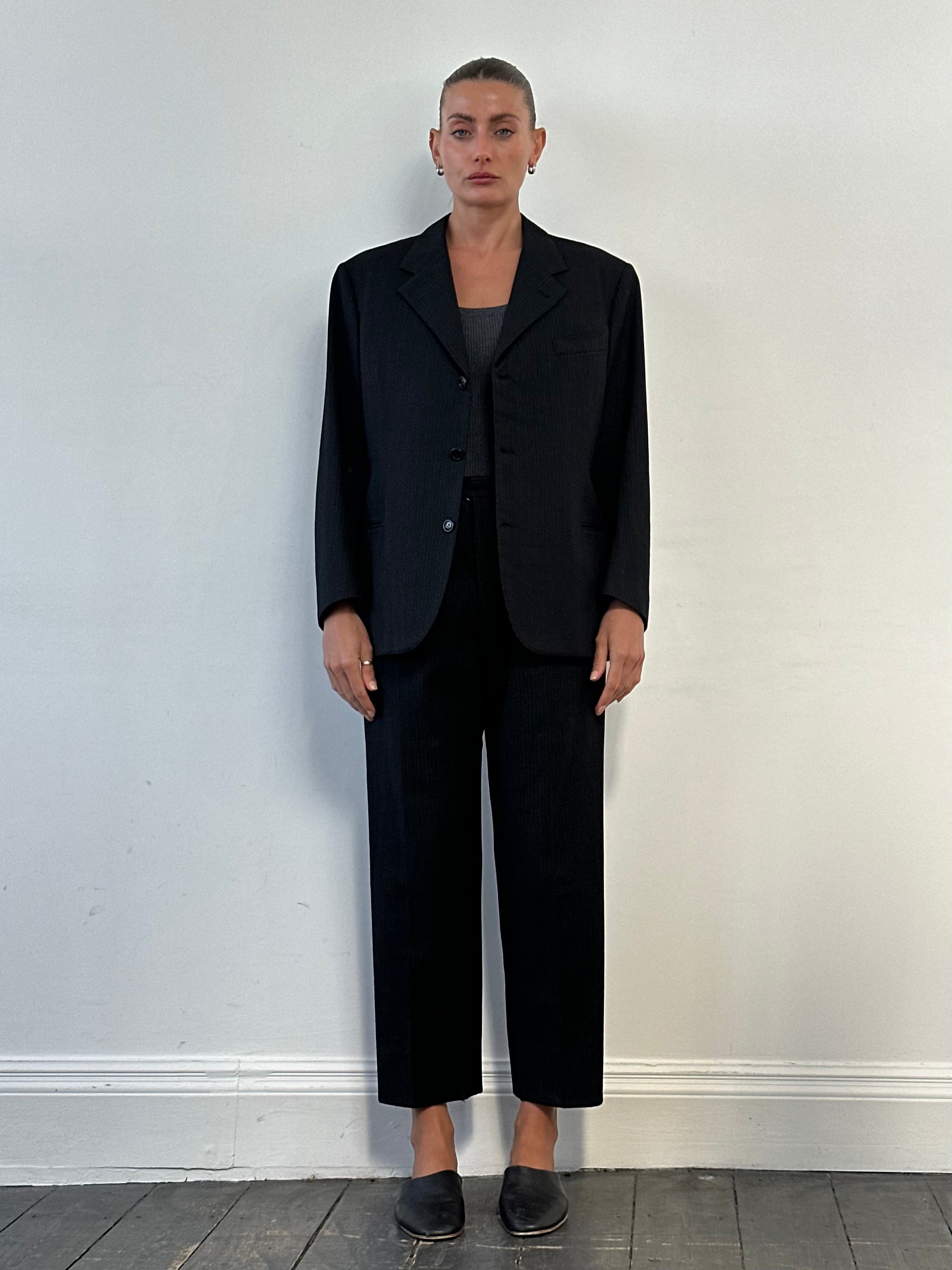 Vintage wool single-breasted suit in size 40R with W28 waist, featuring classic tailoring and a timeless design.