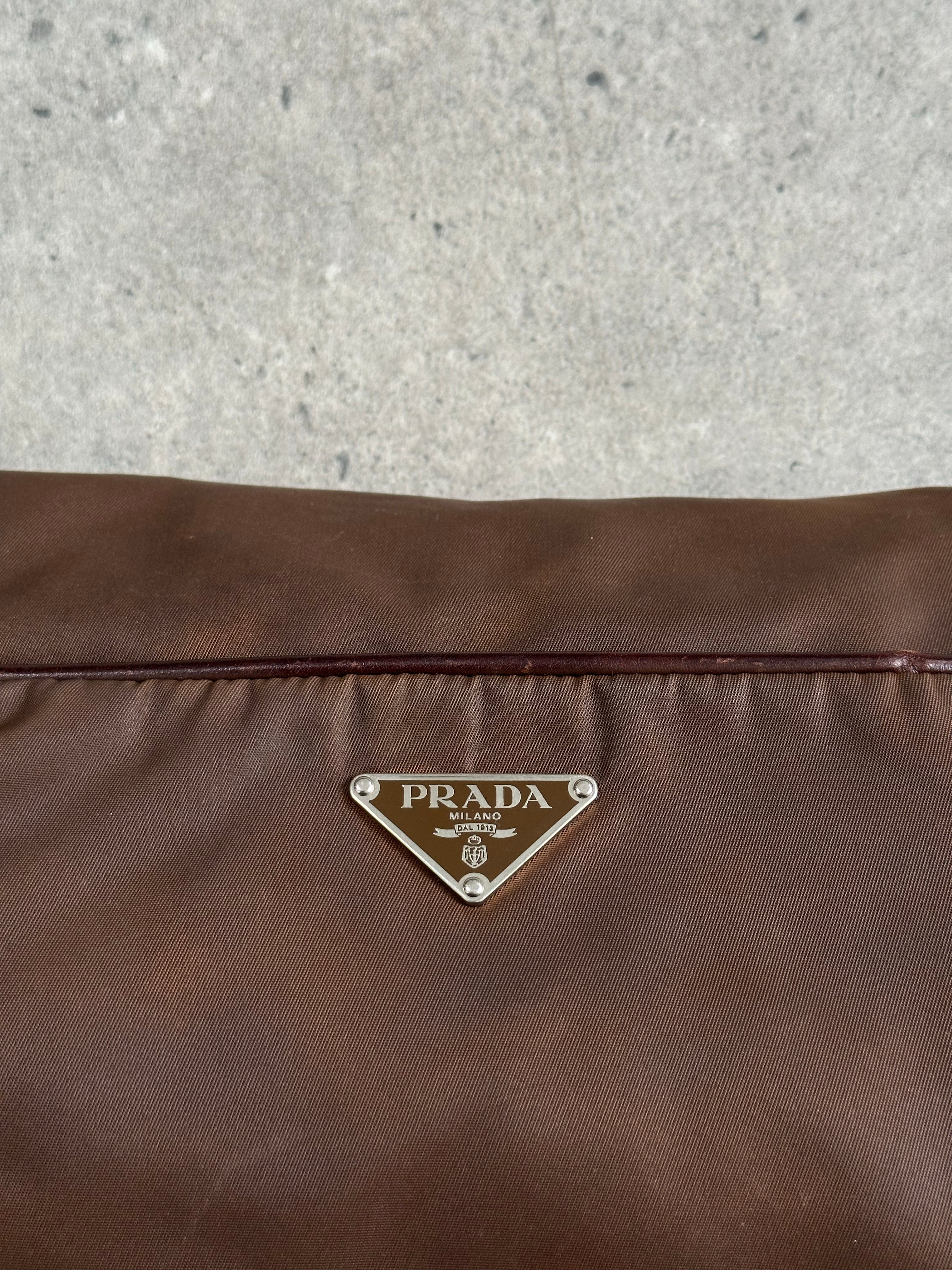 Prada 1990s nylon crossbody bag with adjustable strap and minimalist design, featuring the iconic Prada logo on the front.