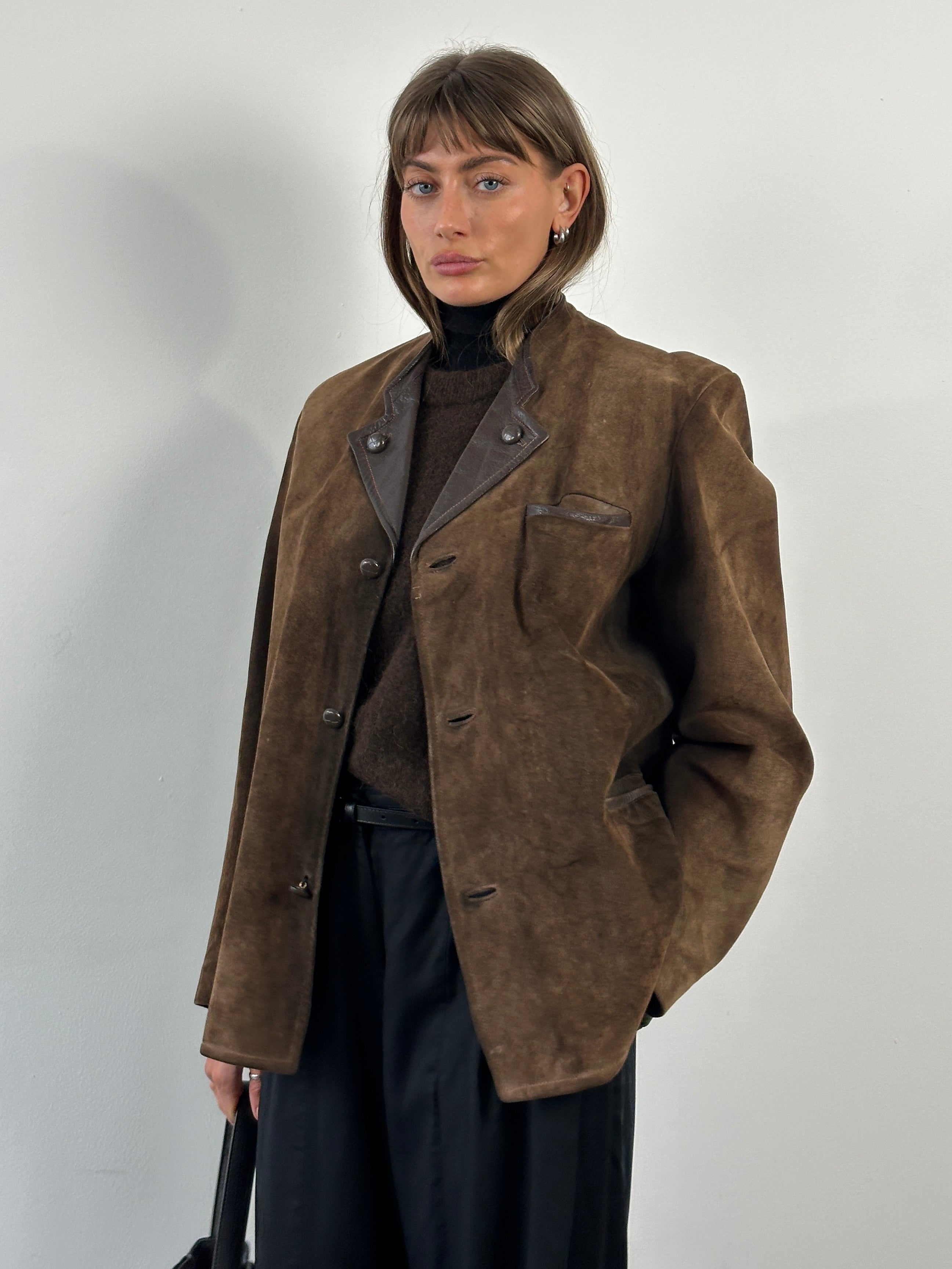 Vintage 1970s suede leather jacket in XL size with classic collar and front zipper, displayed on a hanger.