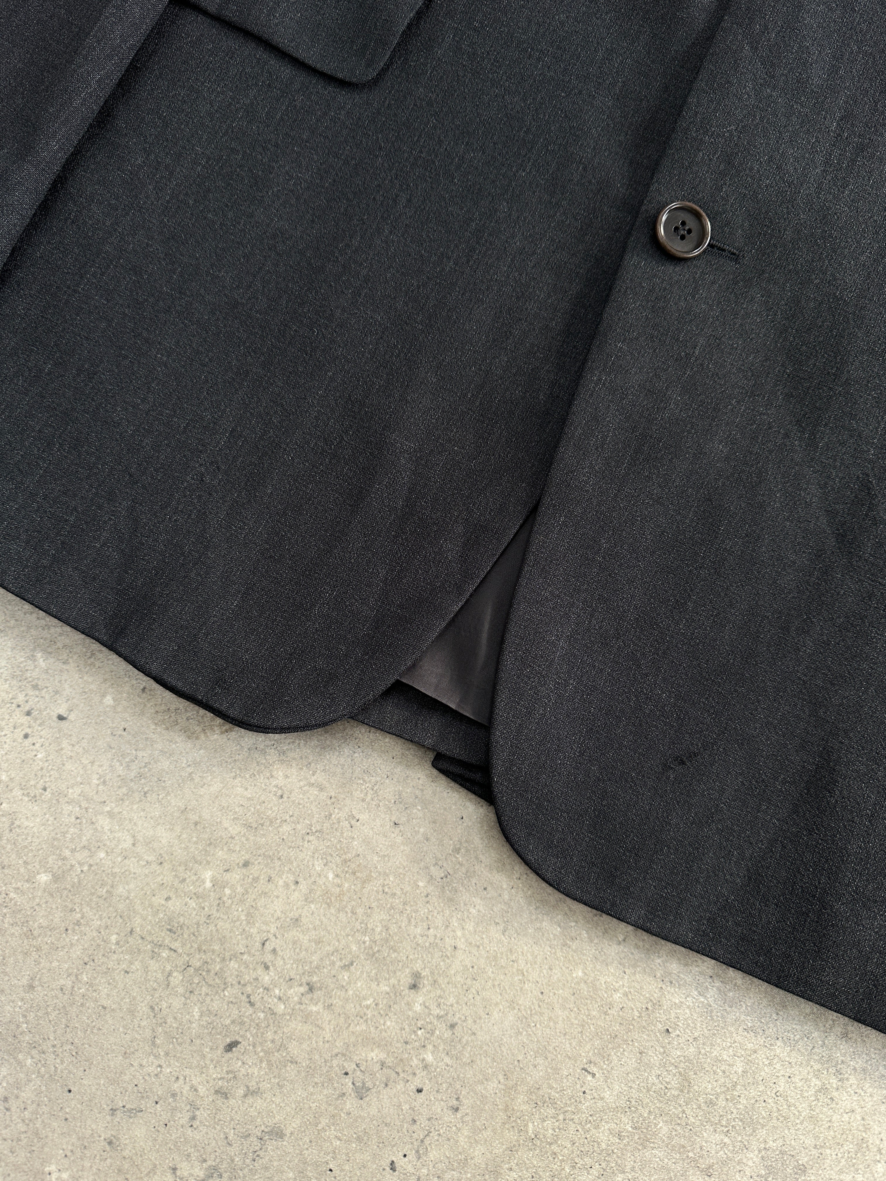 Hugo Boss virgin wool single-breasted blazer in size 42R/XL, tailored fit, in classic dark color, displayed on a hanger.