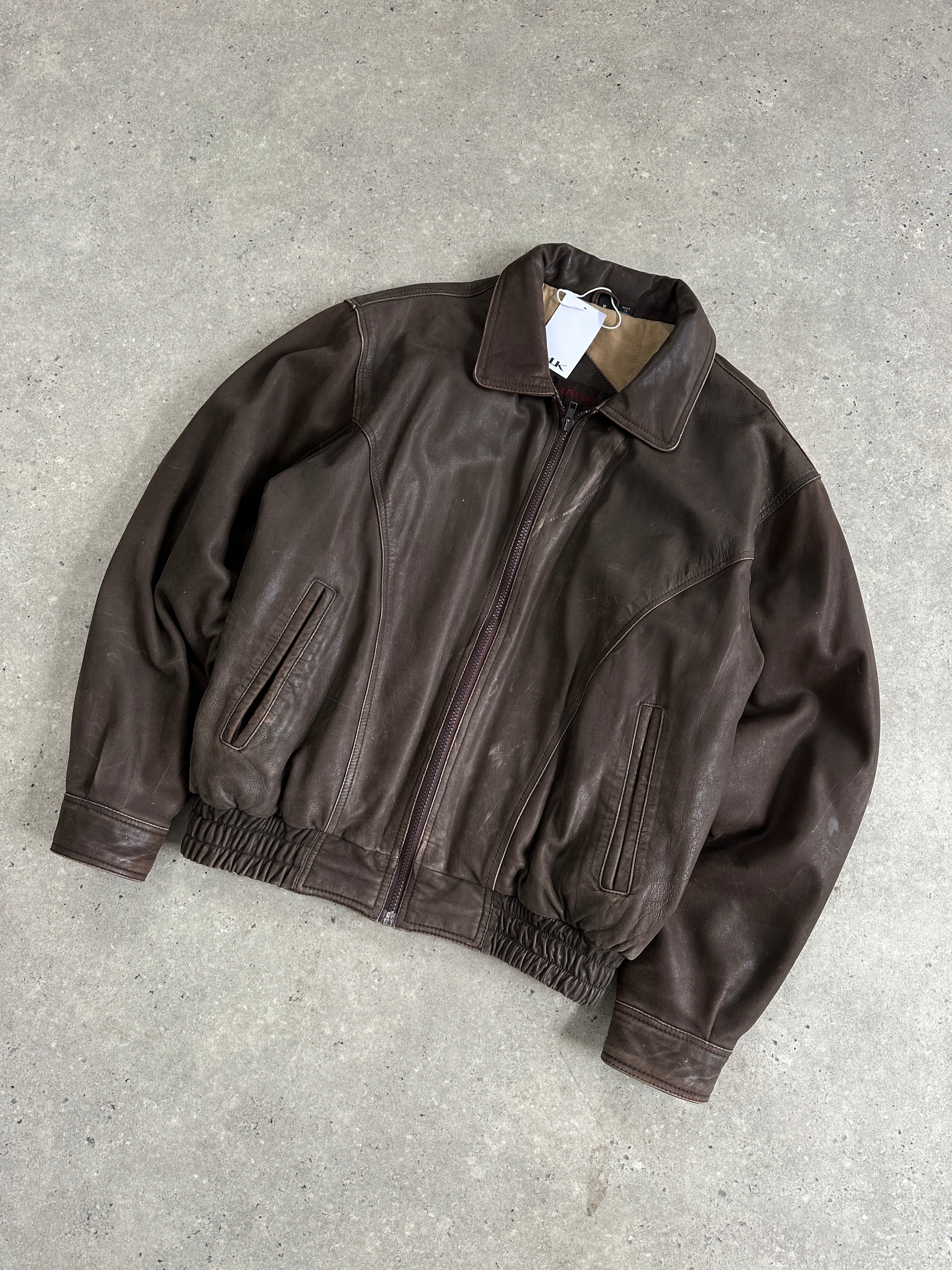 Vintage distressed leather bomber jacket in size M, featuring a rugged design and classic style, shown on a person.