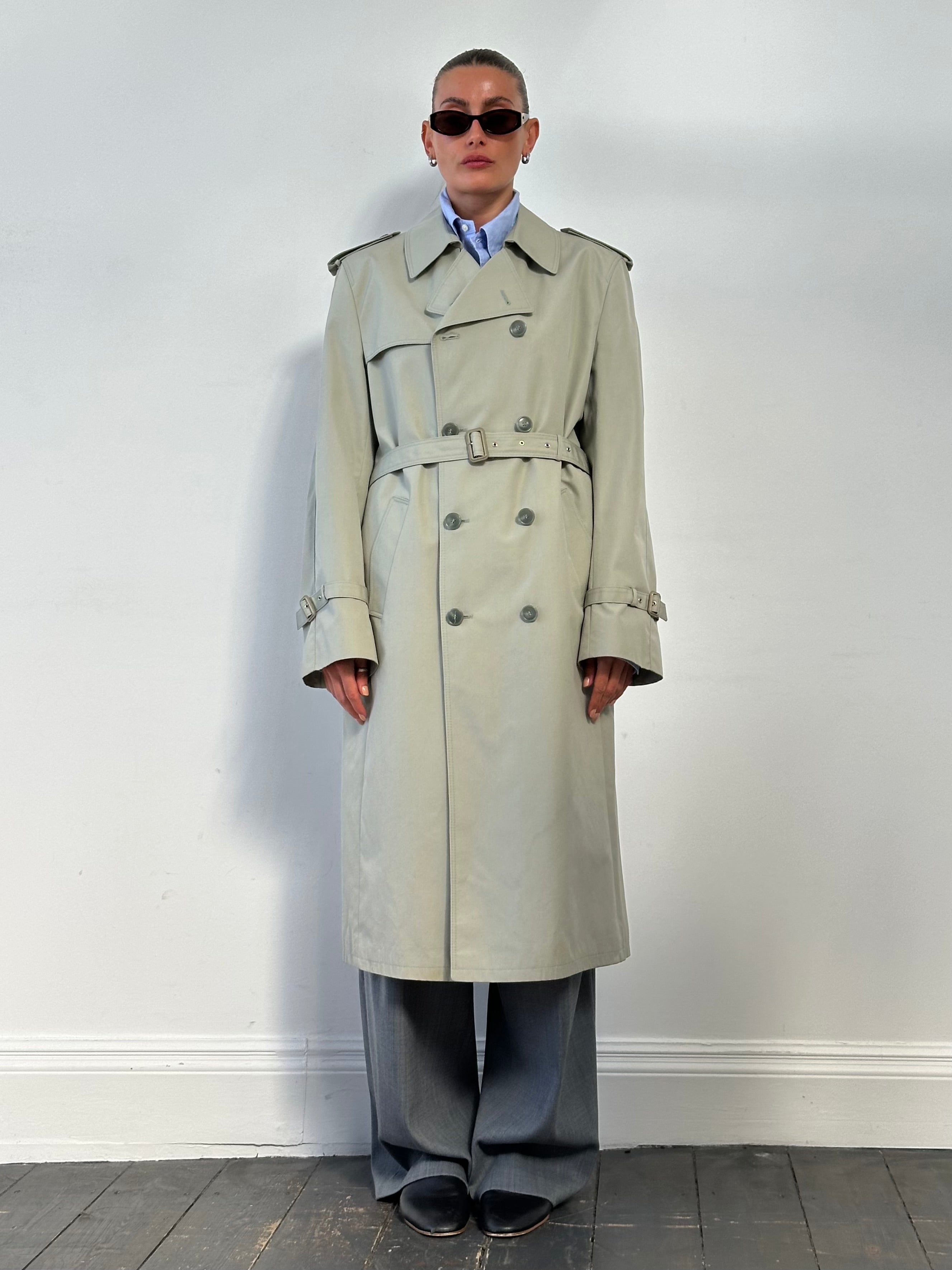 Vintage double-breasted belted trench coat in size XL, featuring classic style and tailored fit, shown on a hanger.
